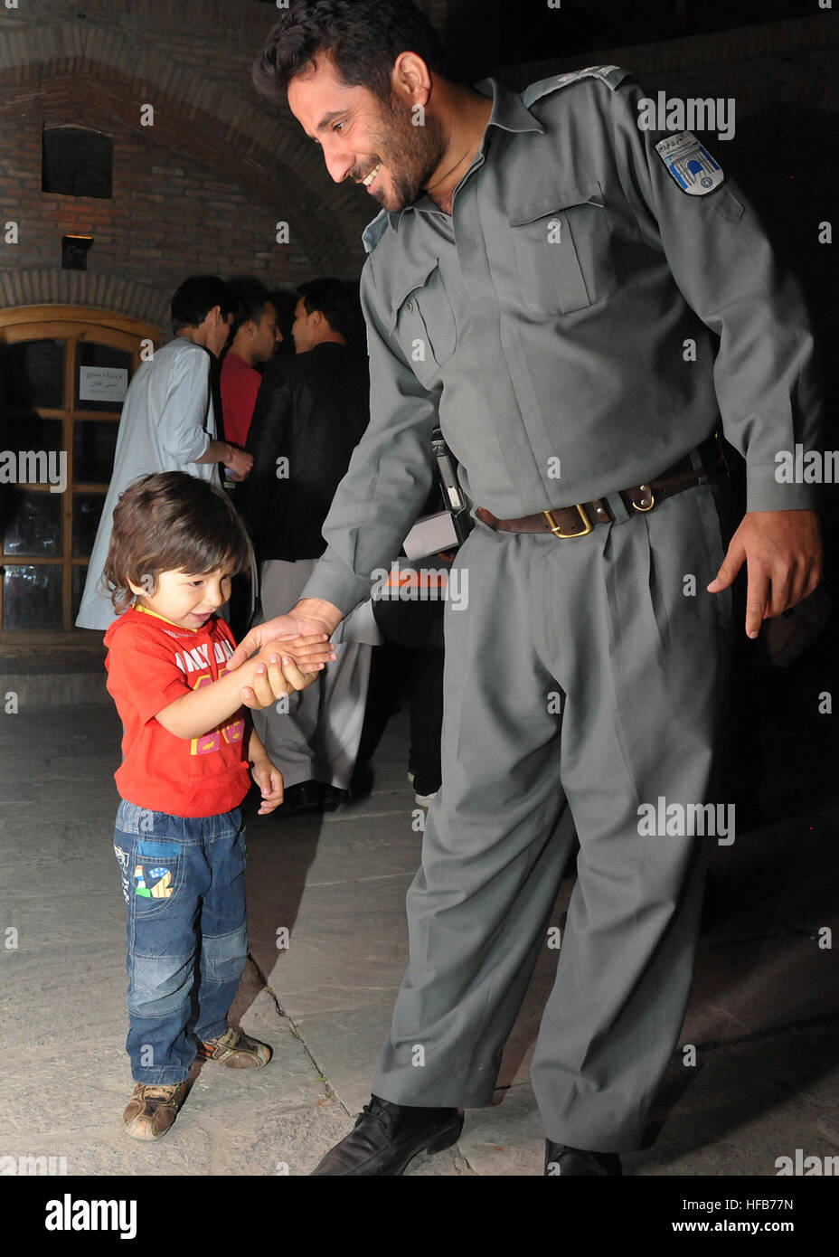 Un officier de la police nationale afghane s'entretient avec un enfant lors du 1er Festival du film de police aux jardins Babur à Kaboul le 21 mai 2012. L'événement d'une semaine visait à favoriser le dialogue culturel, à améliorer les relations communautaires et à créer une perception positive de la force de police afghane. Banque D'Images