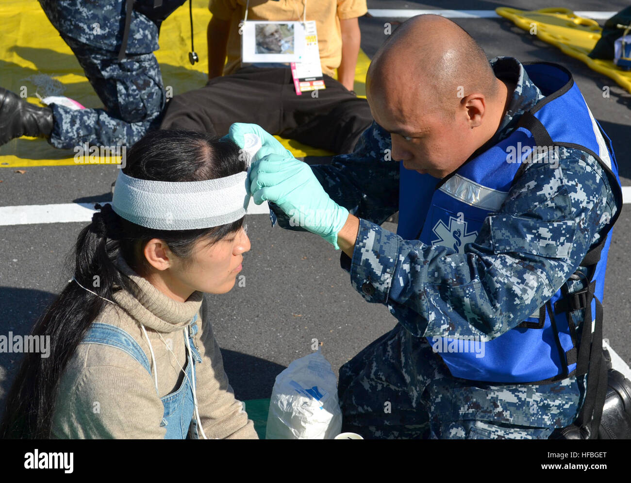 YOKOSUKA, Japon (nov. 7, 2012) 3ème classe Corpsman Hôpital Dennis Mata, affecté à la base navale américaine de Yokosuka de l'hôpital, des enveloppements de la gaze autour de la tête d'un patient simulé lors d'un grand nombre de blessés bilatérales perceuse à Yokosuka, activités de la flotte. L'exercice familiarisé aux États-Unis et Force japonaise d'autodéfense maritime Les marins à leurs responsabilités et démontré l'interopérabilité pour répondre à d'éventuelles catastrophes naturelles un grand nombre de blessés. (U.S. Navy photo de Tim Jensen/libérés) 121107-N-QK202-028 http://www.facebook.com/USNavy http://www.twitter.com/USNavy la conversation Inscrivez-vous http://navylive.dodlive.mil Banque D'Images