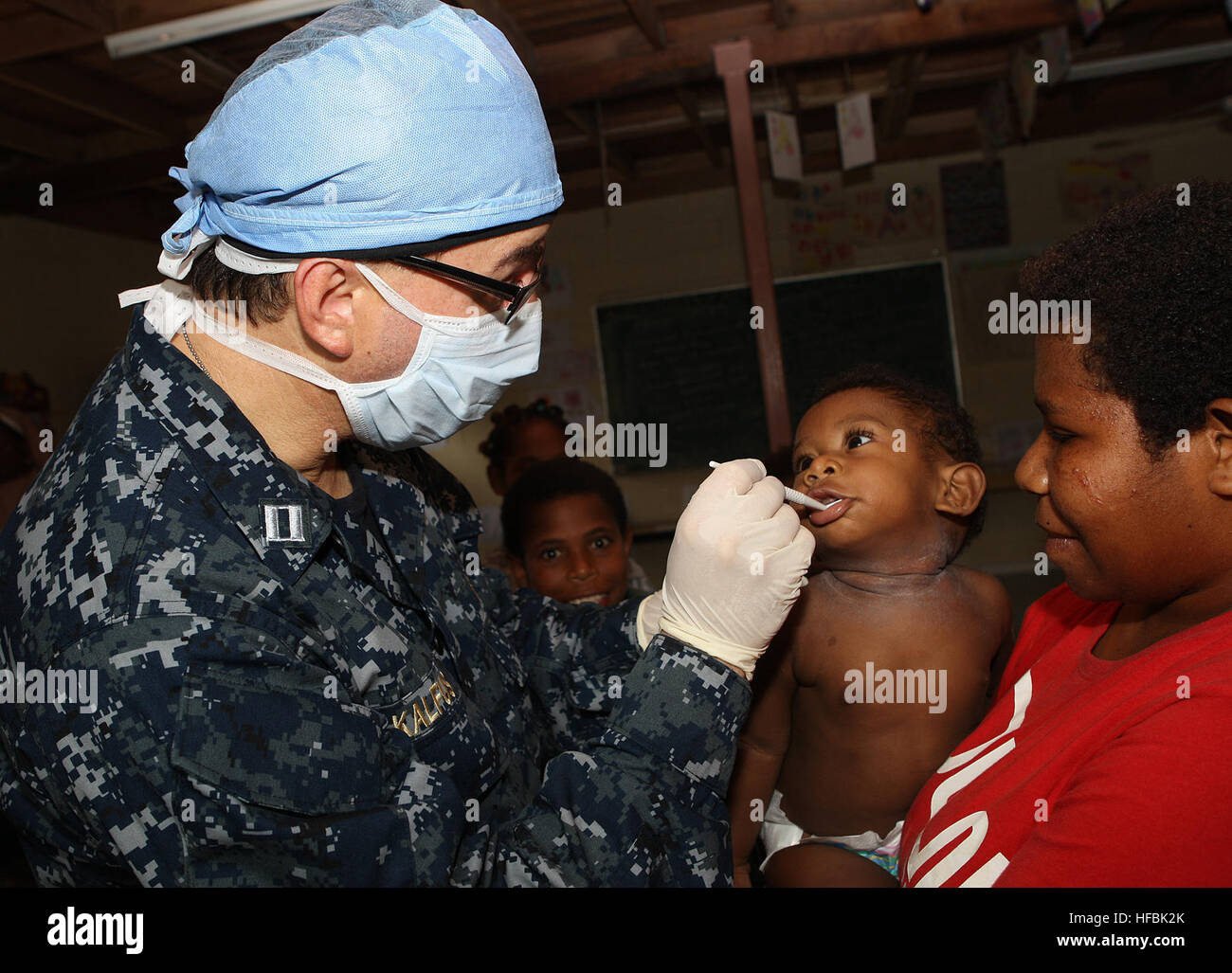 110521-O-AA999-003 LAE, Papouasie Nouvelle Guinée (21 mai 2011) Le lieutenant Arthur Kalfus, un dentiste embarquée à bord de la station de transport amphibie USS Cleveland (7), LPD vérifie une babyÕs les dents au Huas Clare Centre de crise pour les enfants lors d'un partenariat du Pacifique 2011 Projet de service communautaire. Partenariat du Pacifique est un de cinq mois l'aide humanitaire initiative qui a achevé sa mission dans les Tonga et Vanuatu, et visiterez la Papouasie-Nouvelle-Guinée, le Timor Leste, et les États fédérés de Micronésie. (Royal Australian Navy photo par le Matelot Spécialiste imagerie Helen Frank/libérés) - U.S. Navy JE Banque D'Images