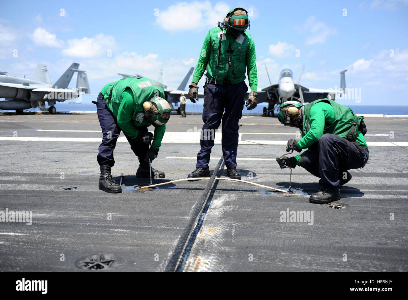 110711-N-DE843-073 OCÉAN ATLANTIQUE (11 juillet 2011) l'Aviation Boatswain's mates remplacer un support de câble de vitesse pendant les opérations de vol à bord du porte-avions USS Dwight D. Eisenhower (CVN 69). Dwight D. Eisenhower est en cours la réalisation des qualifications de l'opérateur en préparation de son prochain déploiement. (U.S. Photo par marine Spécialiste de la communication de masse 3 classe Bradley Evans/libérés) - Imagerie de la marine américaine - Les Marins remplacer un support de câble arrêt à bord de l'USS Dwight D. Eisenhower. Banque D'Images