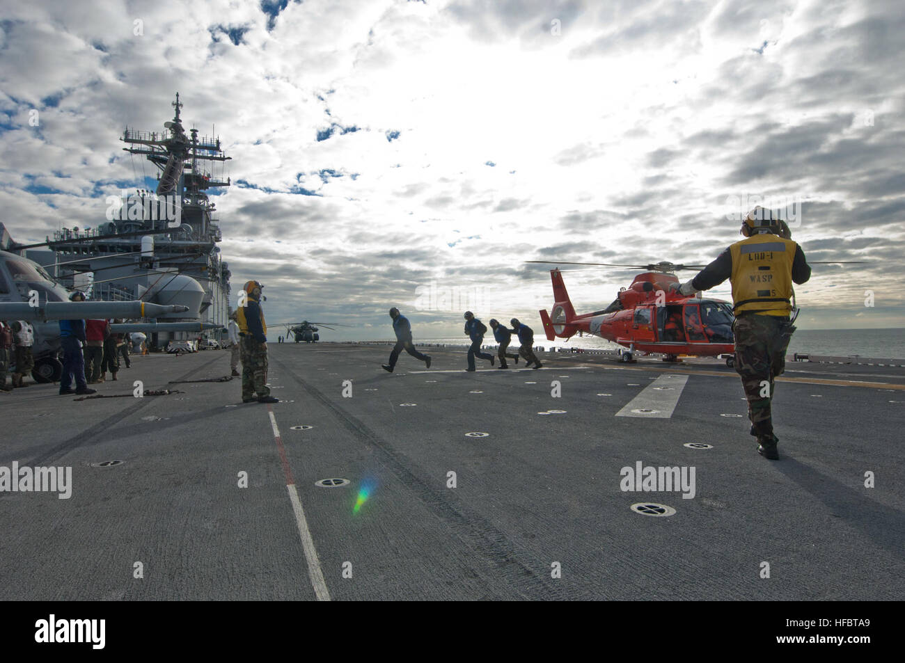 Océan Atlantique (nov. 2, 2012) l'Aviation maître de Manœuvre (manutention) 3e classe Andre Nation dirige une cale et l'équipage de la chaîne d'un MH-65D hélicoptère Dauphin affectés à l'Escadron de la Garde côtière canadienne (CG) 65 dans le poste de pilotage de l'assaut amphibie USS Wasp LHD (1). Pour une planification prudente, la Marine a commencé à approcher le Wasp, USS San Antonio (17), LPD et USS Carter Hill (LSD 50) pour l'assistance primaire dans la région du nord-est touchées si requis par la FEMA a la suite des ravages causés par l'Ouragan Sandy. San Antonio et Carter Hall a débuté le 31 octobre de la Norfolk, en Virginie, et a commencé Banque D'Images