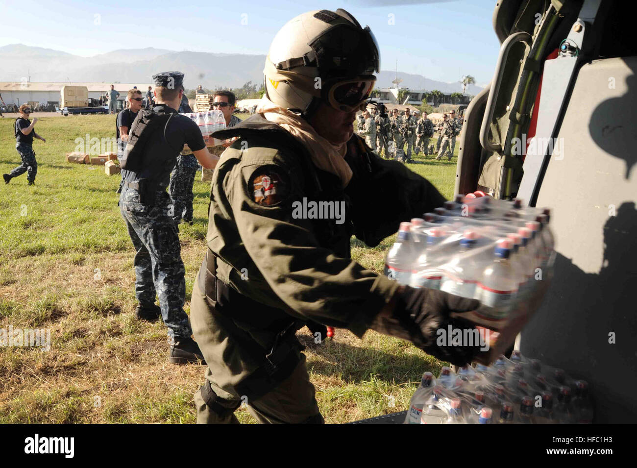 Les marins affectés au porte-avions USS Carl Vinson et les chargeurs d'hélicoptère de combat Mer 26 Escadron préparer les cas de l'eau pour la livraison à l'Aéroport International de Port-au-Prince. Partie-au-Prince a été frappé par un terrible tremblement de terre de magnitude 7, le 12 janvier 2010. Haiti relief efforts 241023 Banque D'Images