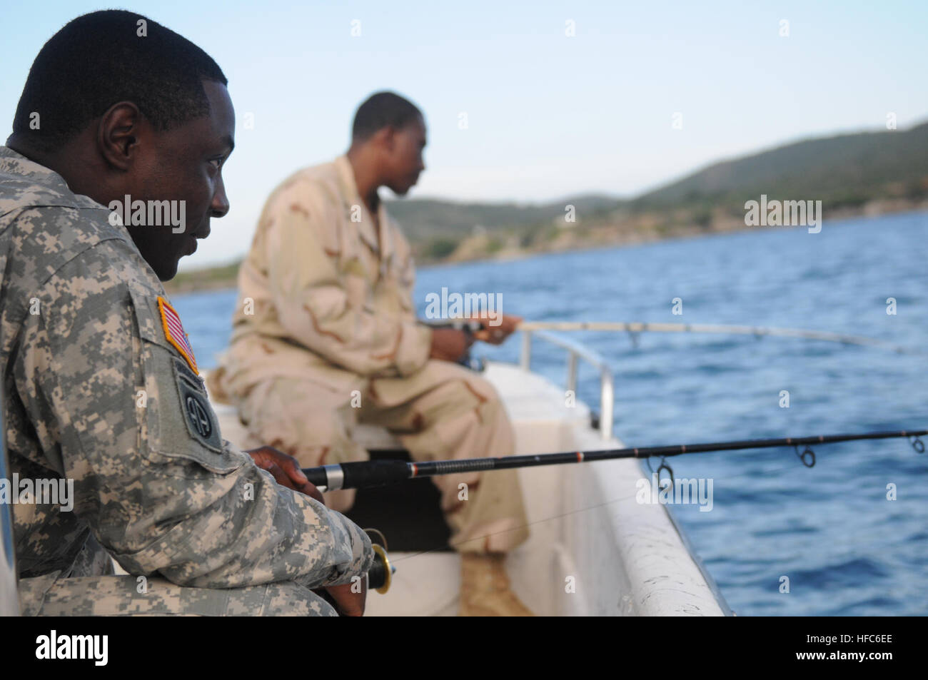 La CPS. Howard Jones (à gauche), un armurier de la 189e Compagnie de Police militaire, sa ligne permet au cours d'une commission militaire voyage de pêche dans la baie de Guantanamo, le 8 juillet. Jones est l'un des nombreux soldats stationnés à la Force opérationnelle navale de Guantanamo et qui se portent volontaires pour enseigner dans le moral de bien-être et de loisirs. Cours de pêche de base Liens sponsorisés Voyage de pêche militaire mixte 110708-N-MN220-117 Banque D'Images