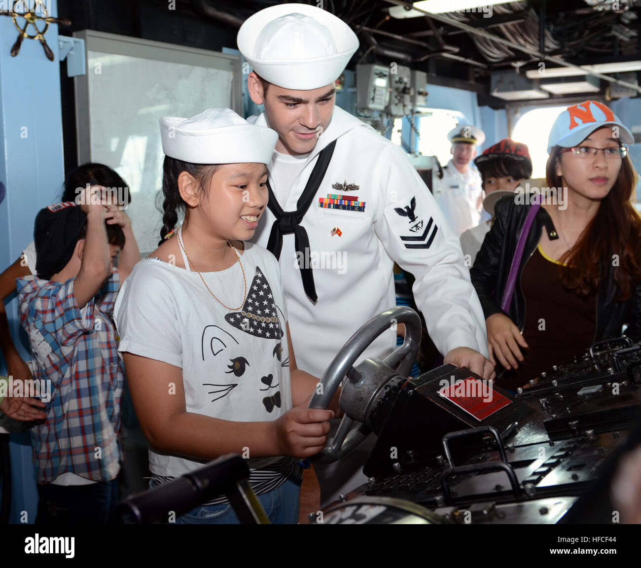 140409-N-YU572-276 Da nang, Vietnam (9 avril 2014) 2ème classe Controlman Feu Randy Kabbourim montre un enfant comment diriger la classe Arleigh Burke destroyer USS John S. McCain (DDG 56) au cours d'une excursion à bord d'un lieu à l'appui de l'activité d'engagement naval (AEN) au Vietnam. L'AEN offre des opportunités pour les professionnels de la marine américaine et vietnamienne pour partager les meilleures pratiques et les compétences maritimes. Les échanges de compétences maritimes entre les deux marines sont des non-combattants, des événements tels que la médecine militaire, de recherche et de sauvetage, de plongée et de sauvetage et de lutte contre les avaries à bord. Environ 400 marins de la Marine américaine et de l'IC Banque D'Images