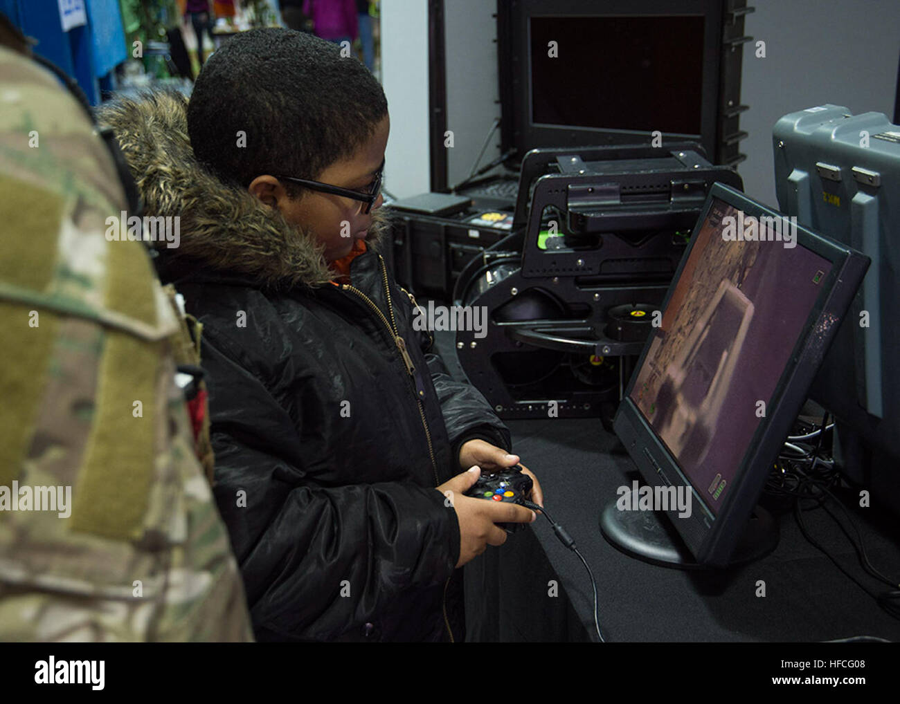 Des explosifs et des munitions de 3e classe Dennis Blair, à gauche, à partir de la neutralisation des explosifs (unité mobile) EODMU 6, montre un étudiant comment utiliser la télécommande pour un système robotique transportable PackBot au Portsmouth Public Schools Science, technologie, ingénierie et mathématiques (STIM) journée événement tenu au Woodrow Wilson High School. Des marins du EODMU 6 et mobile et l'Unité de plongée de récupération (MDSU) 2 a appuyé l'approche communautaire en fournissant une occasion pour les élèves et leurs familles à voir et interagir avec EOD et Marine matériel de plongée de la Marine et des robots à l'événement. (U.S. Photo par Marine Banque D'Images