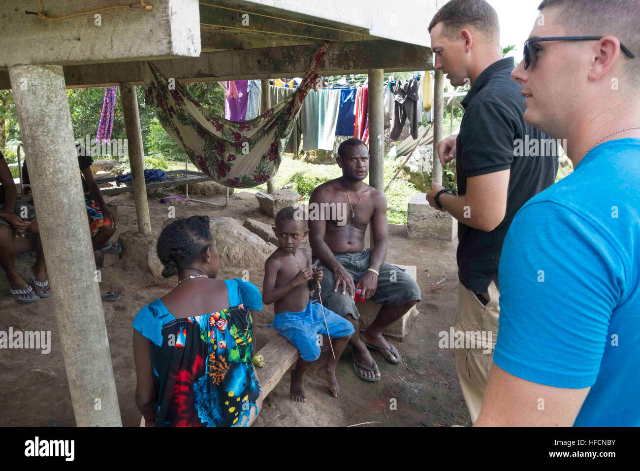 150620-N-FC750-025, ARAWA Papouasie-Nouvelle-Guinée (20 juin 2015) Le lieutenant Cmdr. Andy Hunt et le lieutenant J.G. Tim Dengler, tant dans le cadre d'un partenariat du Pacifique liaison avancée parti, parler d'une famille près de l'ingénierie à l'école, Piruana Arawa, la Papouasie-Nouvelle-Guinée. Maintenant dans sa 10e version, le Pacifique est le plus grand partenariat multilatéral annuel de l'aide humanitaire et des secours de la protection civile a effectué une mission dans la région du Pacifique-Indo-Asia. Bien que l'entraînement pour des conditions de crise, Pacific Partnership missions ont fourni des soins médicaux à environ 270 000 patients et des services vétérinaires Banque D'Images