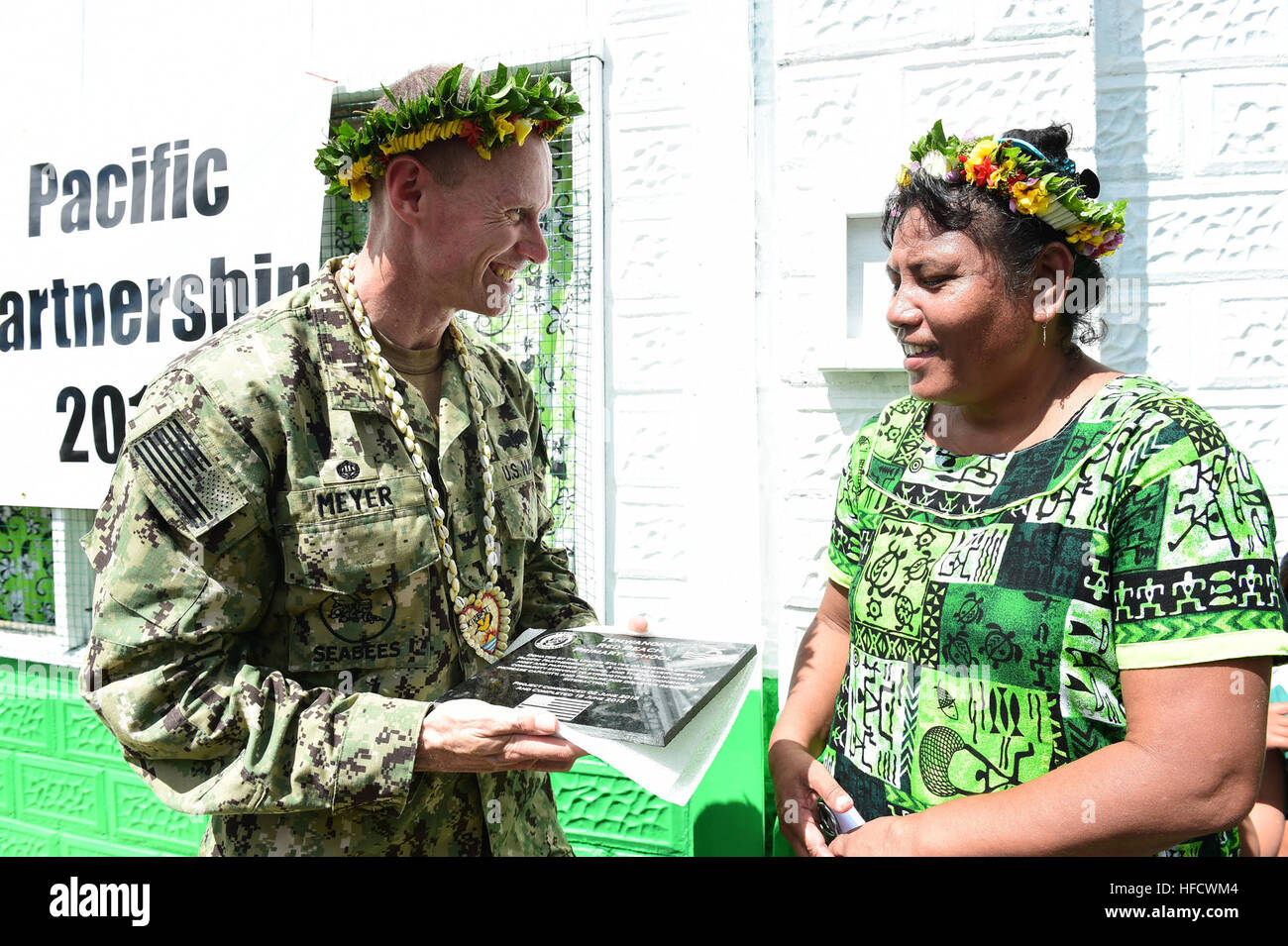 TARAWA, Kiribati (17 juin 2015) - Le Commodore, Groupe de travail butineur Capt James Meyer remet une plaque au directeur de l'école primaire de plage rouge, Mary Noere, lors d'une cérémonie le 17 juin. Coupe le ruban marque l'achèvement des rénovations par Seabees attaché à Pacific Partnership 2015. Butineur Task Force est embarquée à bord de la commande de transport maritime militaire à grande vitesse mixte (JHSV navire USNS Millinocket 3). Millinocket sert de plate-forme de l'enseignement secondaire pour Pacific Partnership, dirigé par un élément de commandement de la force expéditionnaire de la Marine, 30e Régiment de construction navale (30) à partir de la RCN Banque D'Images