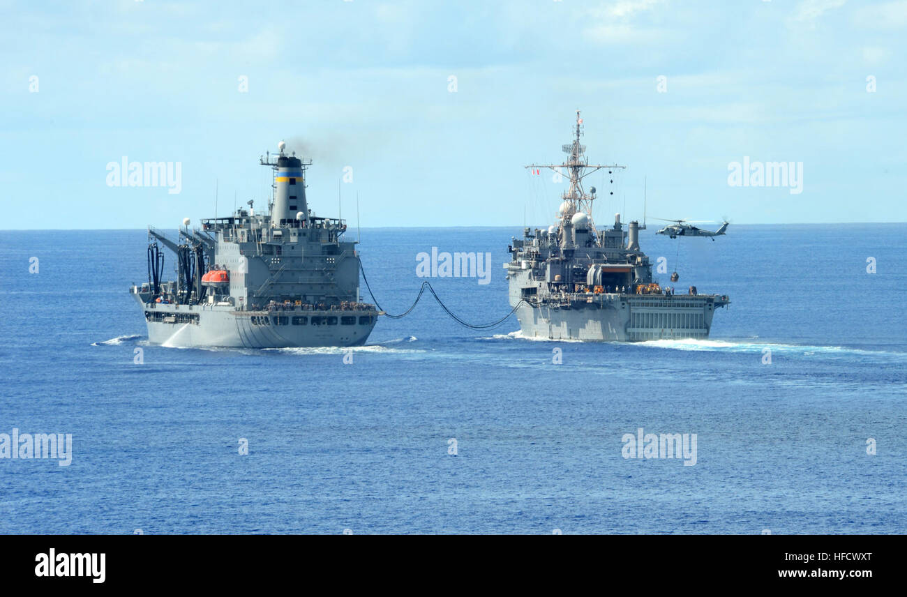 Un MH-60S Sea Hawk abandonne l'alimentation à bord de quai de transport amphibie USS Denver LPD (9) (droit) qu'il reçoit au cours d'un ravitaillement en carburant à partir de la mer Transport maritime La flotte militaire commande de réapprovisionnement oiler USNS John Ericsson (T-AO 195). Denver est une partie de Bonhomme Richard groupe amphibie, le seul de l'avant-déployés ARG, qui est actuellement dans la 7e flotte zone d'opérations. Ravitaillement en mer 120910-N-XY604-017 Banque D'Images