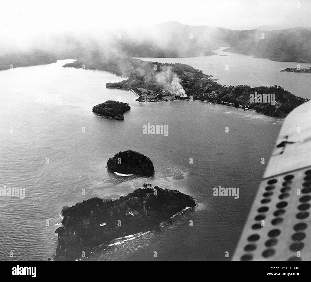 Guadalcanal-Tulagi, Août 1942 : feux brûlent près du terrain de cricket de Tulagi, après bombardement par avions de transport aérien des États-Unis le 7 août 1942, la journée des Marines des États-Unis s'est posé pour capturer l'île. Photographié d'un SMD, ce point de vue ressemble à propos de nord-ouest. Les petites îles au premier plan sont (à partir de la fin de la vue, courir vers Tulagi, tel qu'identifié sur l'impression originale) : Songonangona Kokomtabu, et Mbangai. La photographie originale est venu de l'arrière l'amiral Samuel Eliot Morison's World War II history project fichiers de travail. U.S. Naval Historical Center photo. TulagiAerial2 Banque D'Images