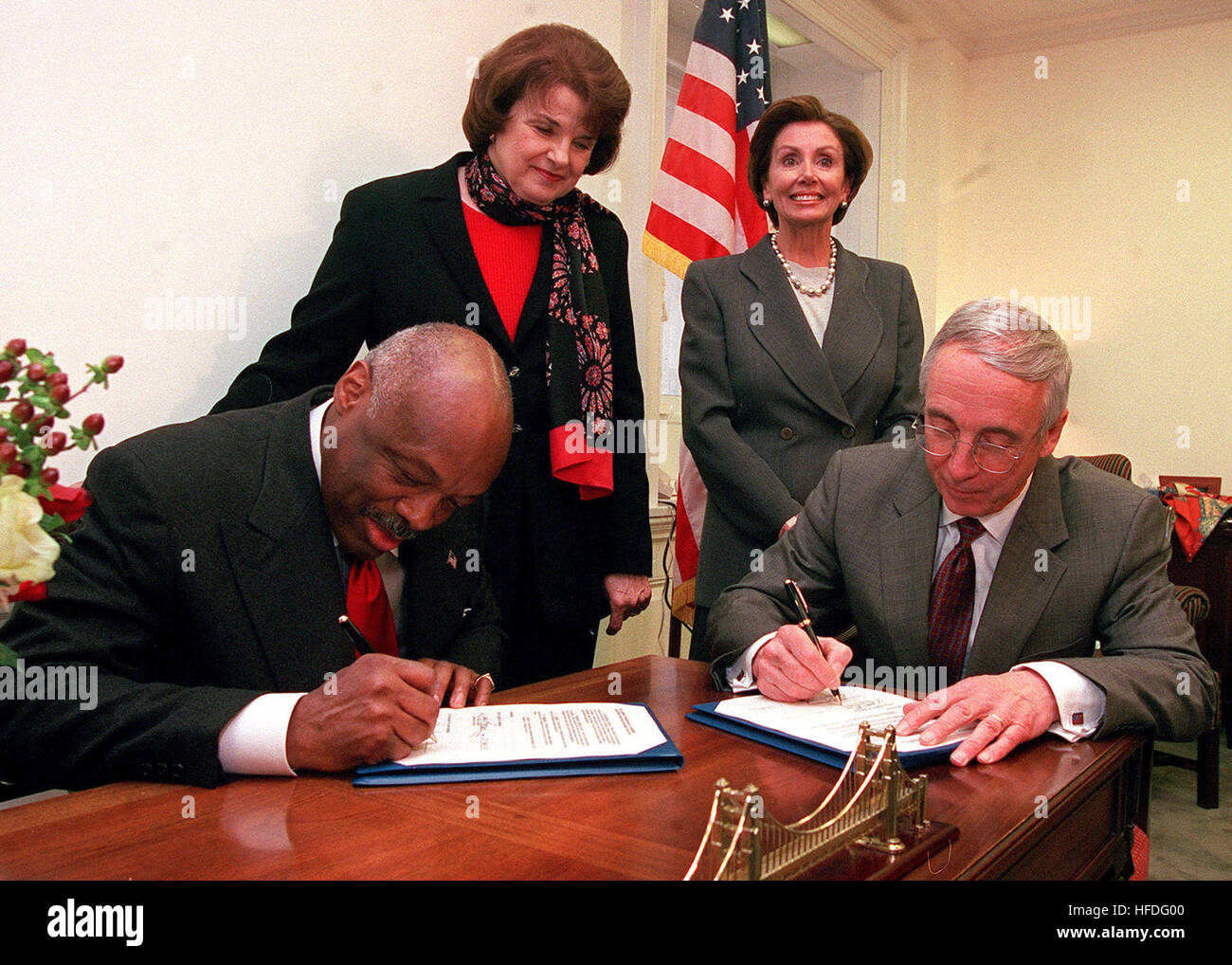 020123-N-5636P-001 Capitol Hill, Washington, D.C. (janv. 23, 2002) -- Le secrétaire de la Marine l'honorable Gordon England (à droite), signe un accord avec le maire de San Francisco Willie Brown (à gauche), le transfert de l'ancien Hunter's Point Naval Ship Yard pour la ville de San Francisco, CA, lors d'une cérémonie tenue dans le bureau de Mme Nancy Pelosi (D-Calif.), (en haut à droite). La sénatrice Dianne Feinstein (D-Calif.), (en haut à gauche) a aidé à parrainer un projet de loi pour nettoyer Hunter's Point avant son transfert. L'accord permet à la ville de développer des parcelles de terres prêtes, tandis que l'assainissement de l'installation continue. U Banque D'Images