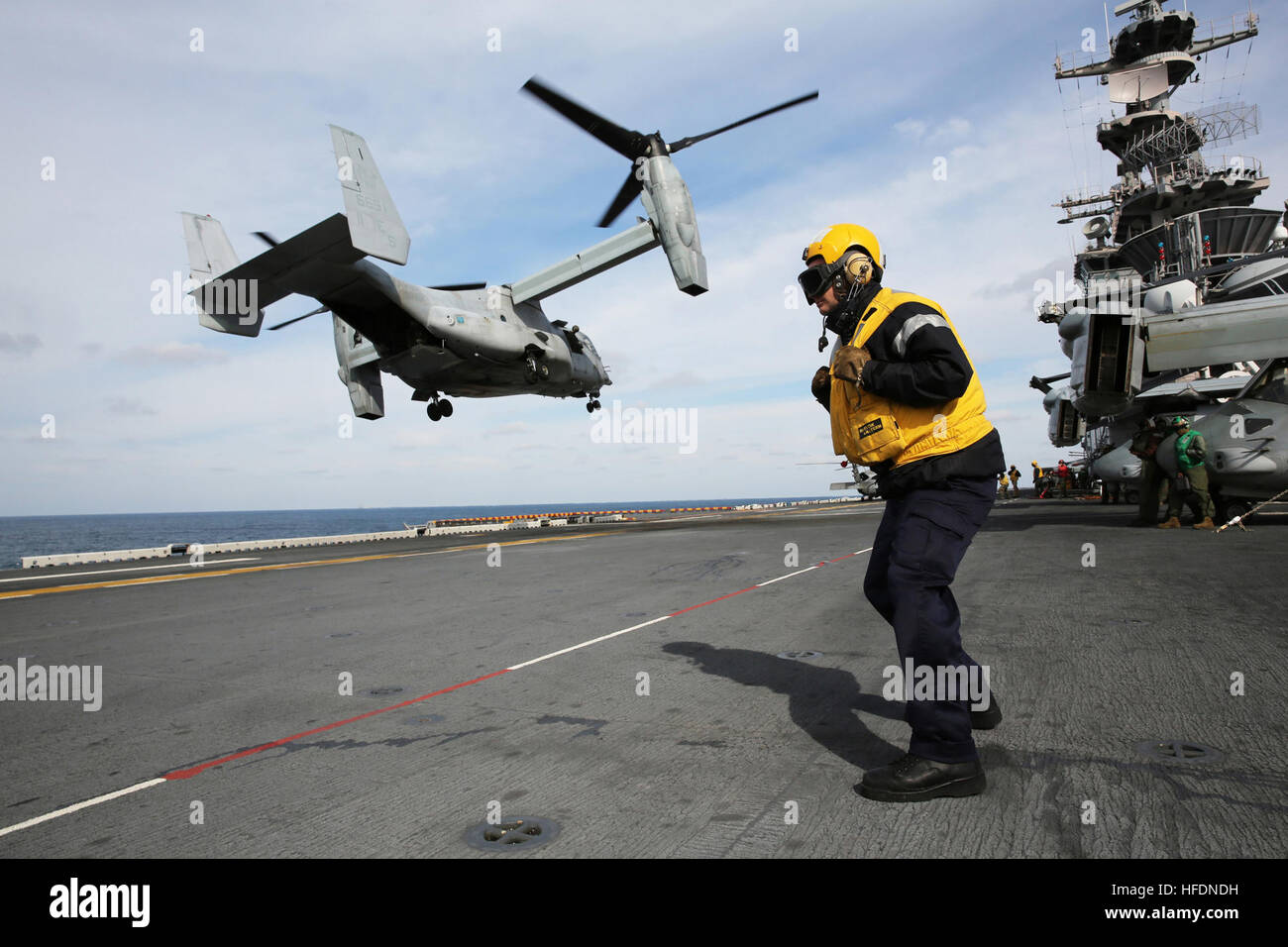 Océan Atlantique (fév. 14, 2013) aviateur (gestionnaire d'aéronefs) Wayne de la Royal Navy Bowring se tient sur le pont d'envol du navire d'assaut amphibie USS Kearsarge LHD (3) tandis qu'un MV-22 Osprey décolle. Kearsarge participe à un exercice de l'unité de formation composite (COMPTUEX) au large de la côte Est des États-Unis en vue d'un déploiement à venir ce printemps. (U.S. Photo par marine Spécialiste de la communication de masse 2e classe Corbin J. Shea/libérés) 130214-N-SB587-072 http://www.facebook.com/USNavy http://www.twitter.com/USNavy Rejoignez la conversation une http://navylive.dodlive.mil B Banque D'Images