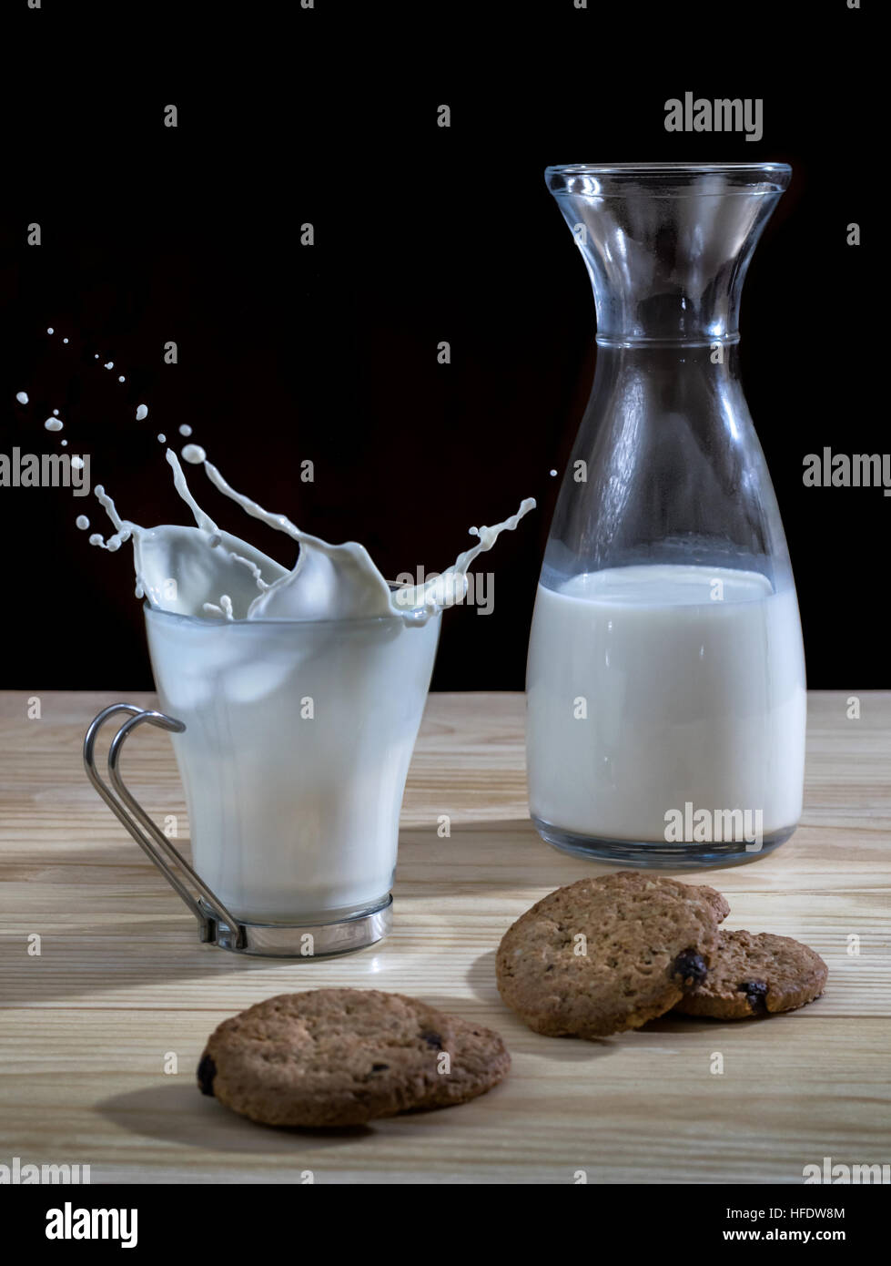 Bouteille et verre de lait avec des biscuits et des vagues sur une table en bois Banque D'Images