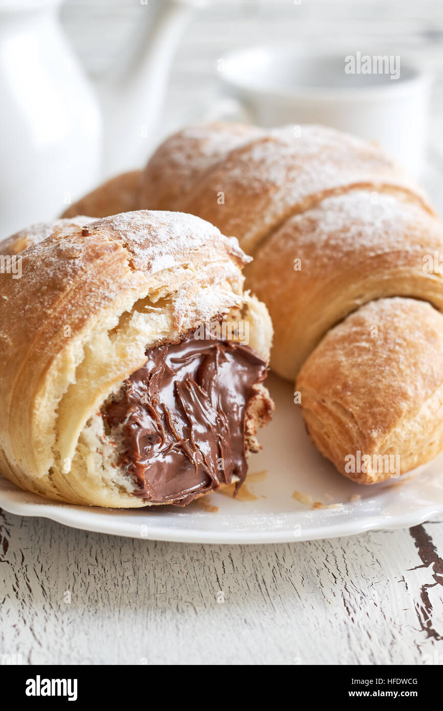 Croissants avec garniture au chocolat sur fond de bois rustique blanc Banque D'Images