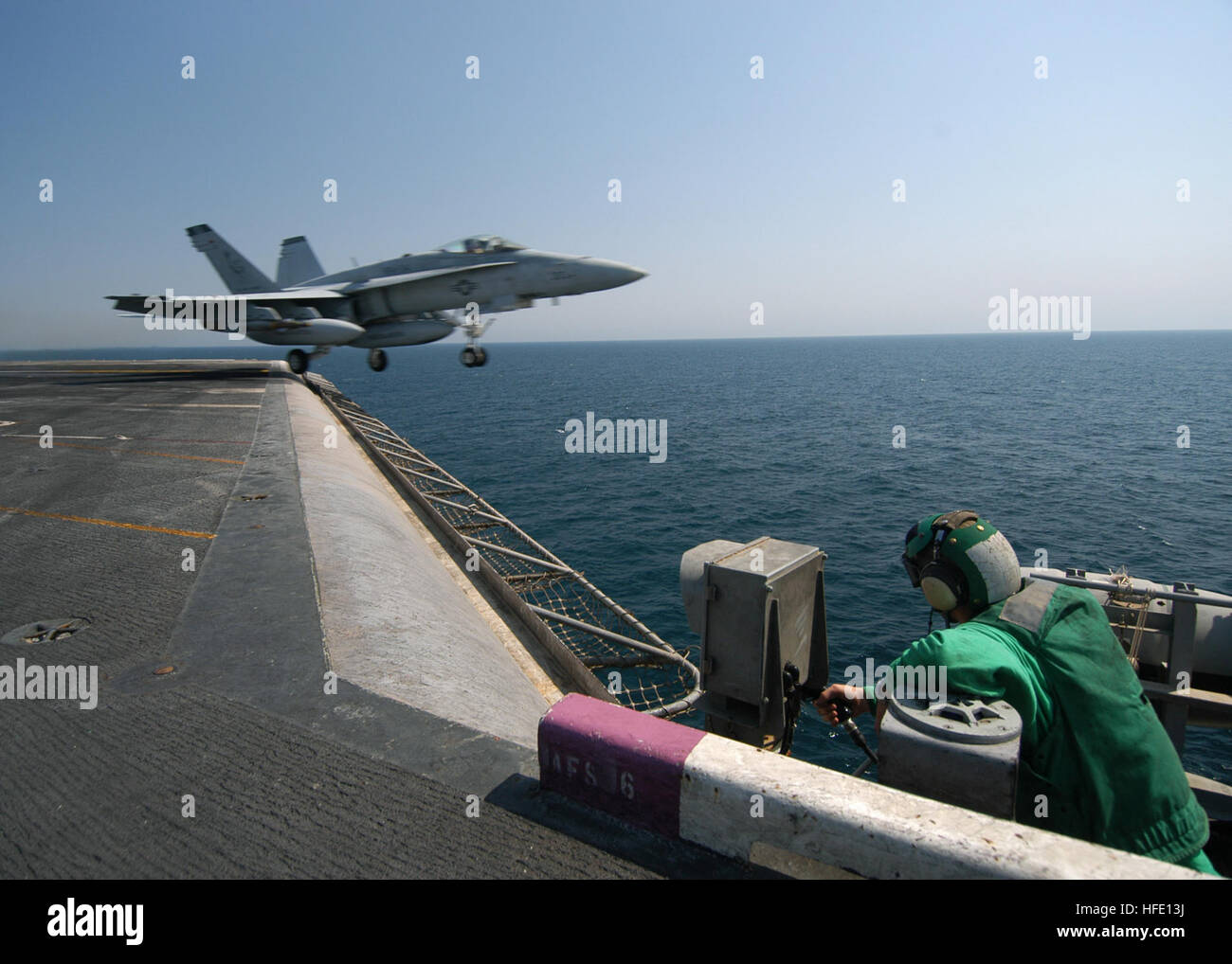040720-N-4190W-001 le golfe Arabique (20 juillet 2004) - Un aviateur affecté à la division de l'air DepartmentÕs V-2 regarde un F/A-18B Hornet affectés à l 'Blue Blasters' de Strike Fighter Squadron trois quatre (VFA-34) prend son envol comme l'USS John F. Kennedy (CV 67) traverse le golfe Persique dans le cadre de l'opération Iraqi Freedom. De plus, Kennedy est actuellement en charge d'impulsion de l'été 2004. Impulsion d'été 2004 est le déploiement simultané de sept groupes aéronavals (SCE), démontrant la capacité de la Marine pour fournir la capacité de combat crédible à travers le globe, dans cinq salles avec d'autres Banque D'Images