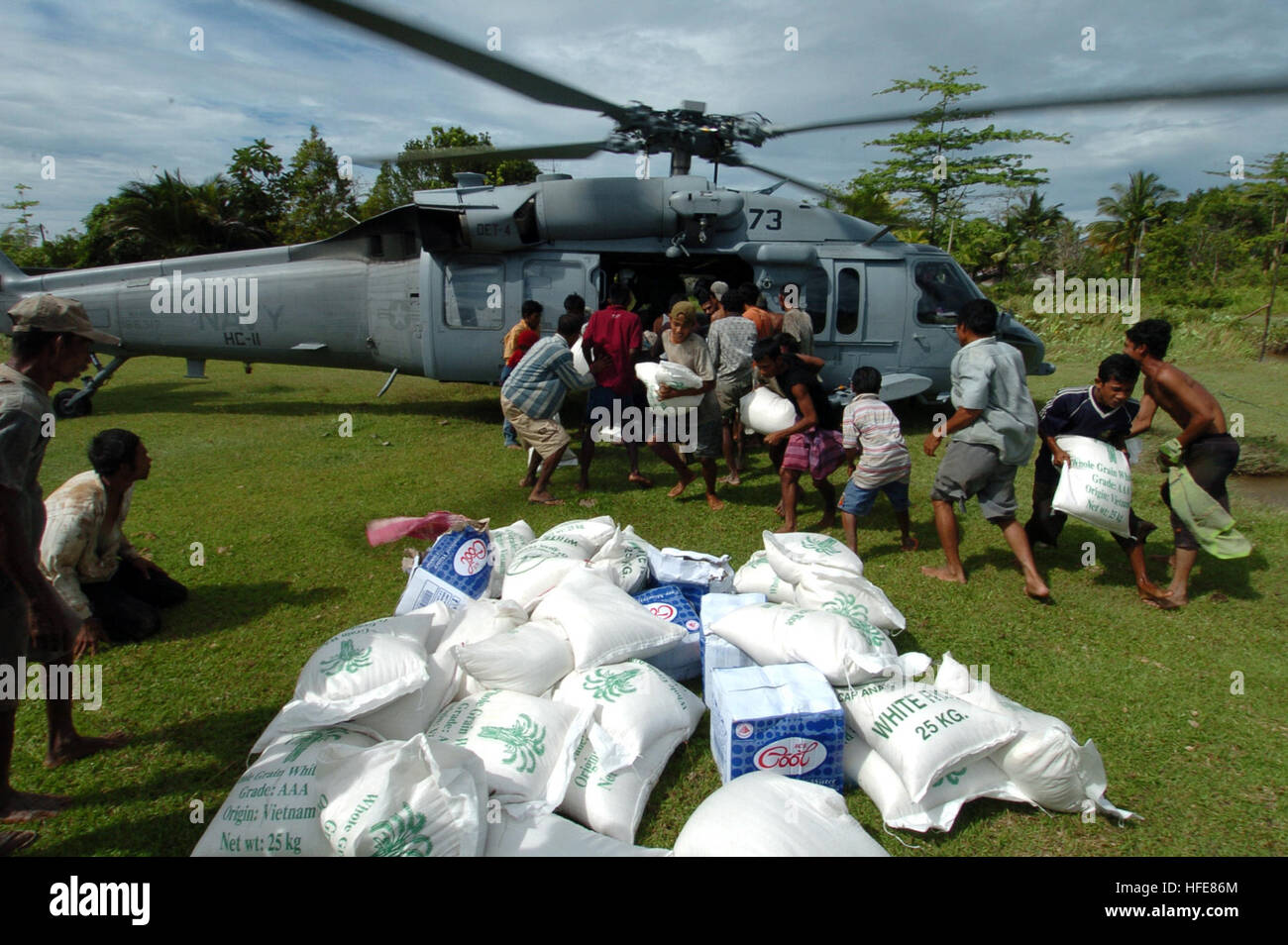 050113-N-9885M-088 de Sumatra, Indonésie (janv. 13, 2005) - Les victimes de l'un tsunami 26 décembre MH-60S Knighthawk hélicoptère comme membres d'équipage affectés à l'hélicoptère d'ÒGunbearersÓ 11 e Escadron de soutien au combat (SC-11) décharger des approvisionnements de secours. Les marins de l'HC-11 sont affectés à l'USS Bonhomme Richard (DG 6), qui fait partie de la groupe expéditionnaire cinq (ESG-5). Bonhomme Richard est actuellement dans l'Océan Indien au large des côtes de l'Indonésie et la Thaïlande, dans le cadre de l'opération Unified Assistance, l'opération humanitaire d'efforts à la suite du tsunami qui a frappé l'Asie du Sud Est. Na américain Banque D'Images