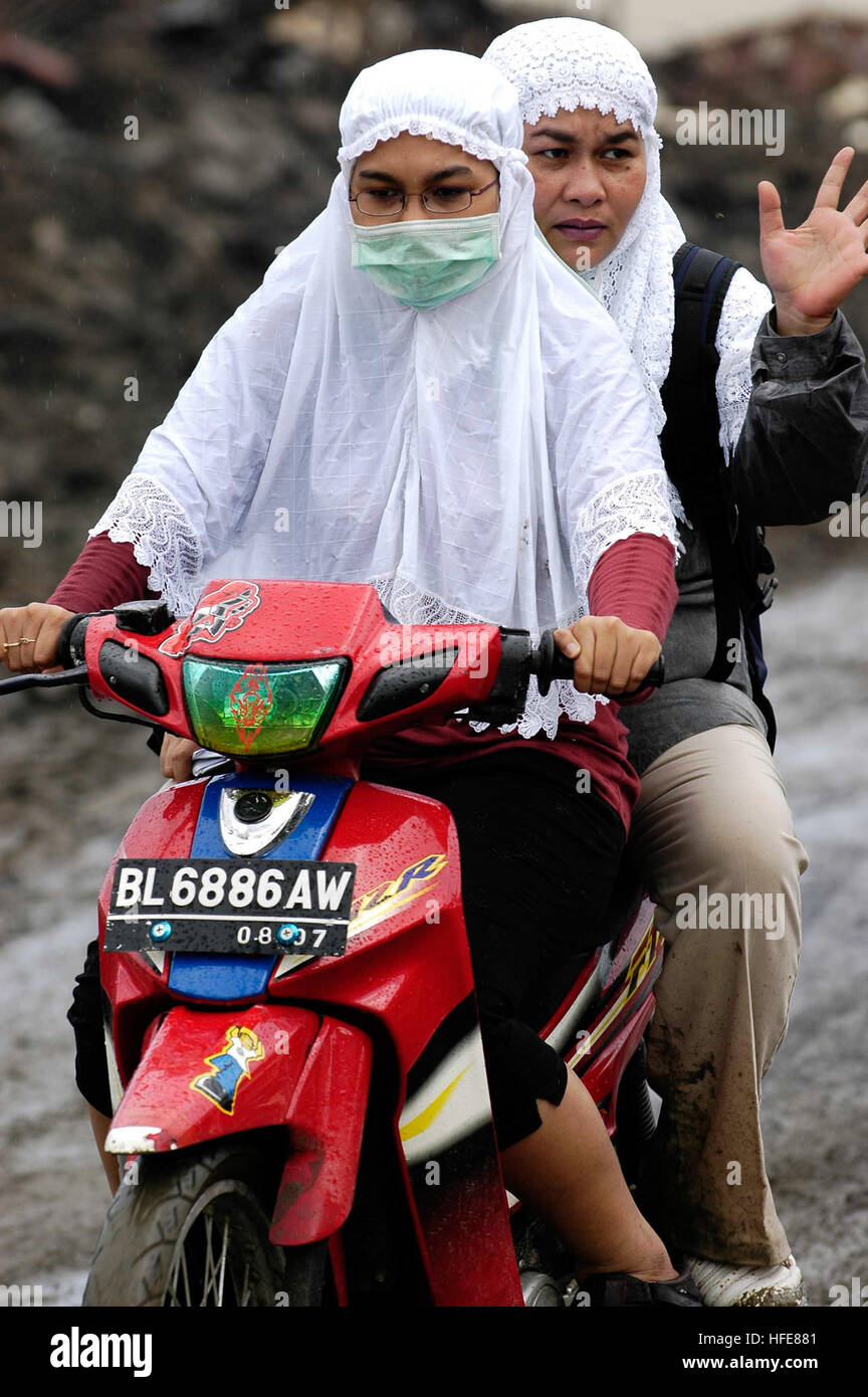 050114-N-4166B-031 Banda Aceh, Sumatra, Indonésie (janv. 14, 2004) - Les femmes indonésiennes sur un tour de moto de retour de leur maison qui a été détruite par le tsunami qui a frappé la région de Banda Aceh, Sumatra, Indonésie. L'Abraham Lincoln et son escadre aérienne de transporteur a entrepris deux (CVW-2) sont actuellement en exploitation dans la région de l'Océan Indien au large des côtes de l'Indonésie et la Thaïlande, dans le cadre de l'opération Unified Assistance, l'effort humanitaire à la suite du tsunami qui a frappé l'Asie du Sud Est. U.S. Navy photo by PhotographerÕs Mate Airman Jordon R. Beesley (libéré) US Navy 050 Banque D'Images