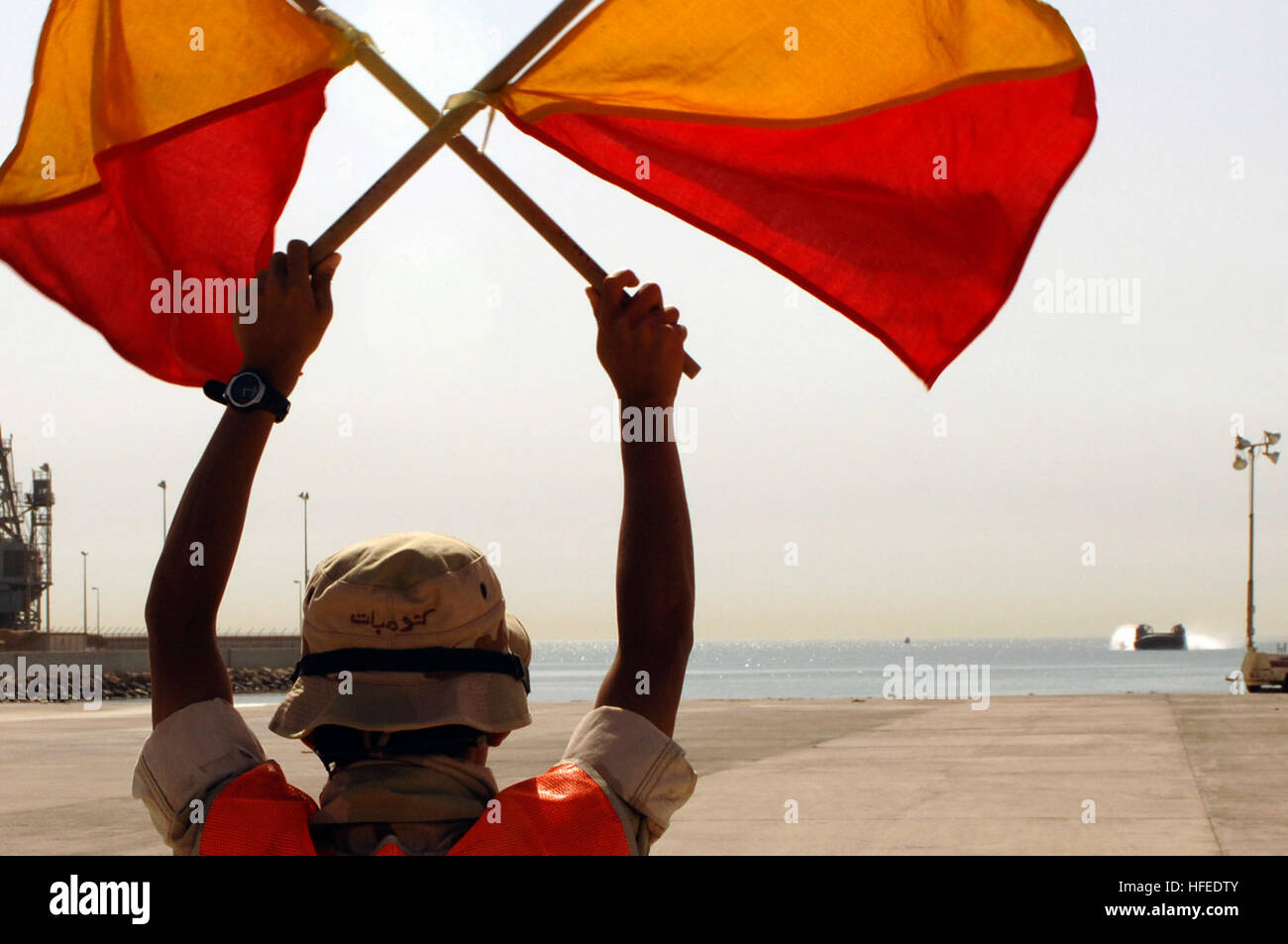 050601-N-4309A-091 de la base navale de Koweïtiens (1 juin 2005) - Contremaître, Seaman Kai Xiong, attribué à Beach Master Unit deux (BMU-2) signale à un Landing Craft Air Cushion (LCAC) pendant le transport de la machinerie lourde, de l'équipement Naval Base koweïtienne. LCACs attachés à l'unité d'assaut quatre (ACU-4) sont actuellement déployés à l'assaut amphibie USS Kearsarge LHD (3) et le navire de débarquement amphibie USS Ashland dock (LSD 48) à l'appui des opérations de transport avec la 26e MEU. U.S. Navy photo by Photographer's Mate 1re classe Ansarov (Aaron) PARUTION US Navy 050601-N-4309un contremaître, S-091 Banque D'Images