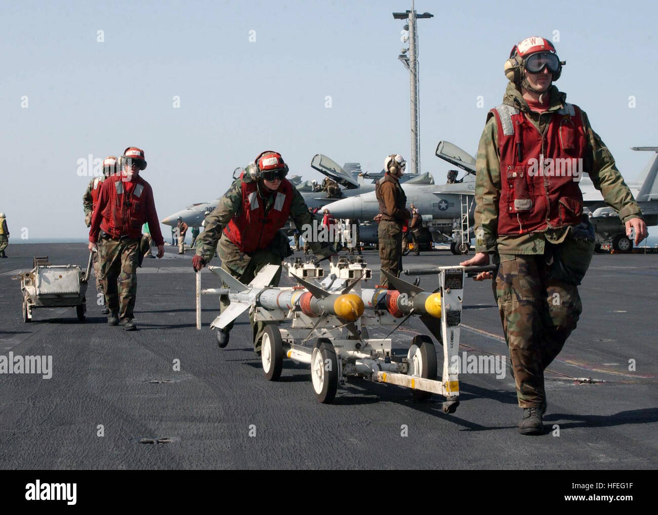 030226-N-6817C-001 en mer à bord du USS ABRAHAM LINCOLN (CVN 72) Feb 25, 2003 -- Ordnancemen affecté à l'aviation d'ÒStingersÓ Strike Fighter Squadron One One trois (VFA 113), déplacer des missiles AIM-9 ÒSidewinderÓ à une zone de stockage sur le shipÕs d'envol après leur retrait à partir d'un F/A-18C ÒHornet.Ó Lincoln et Carrier Air Wing quatorze (CVW-14) sont des opérations de combat dans le cadre de l'opération Southern Watch. U.S. Navy photo by Photographer's Mate Airman Elizabeth Bartneck. (Libéré) US Navy 030226-N-6817C-001 la manutention des armes à bord du USS Abraham Lincoln Banque D'Images