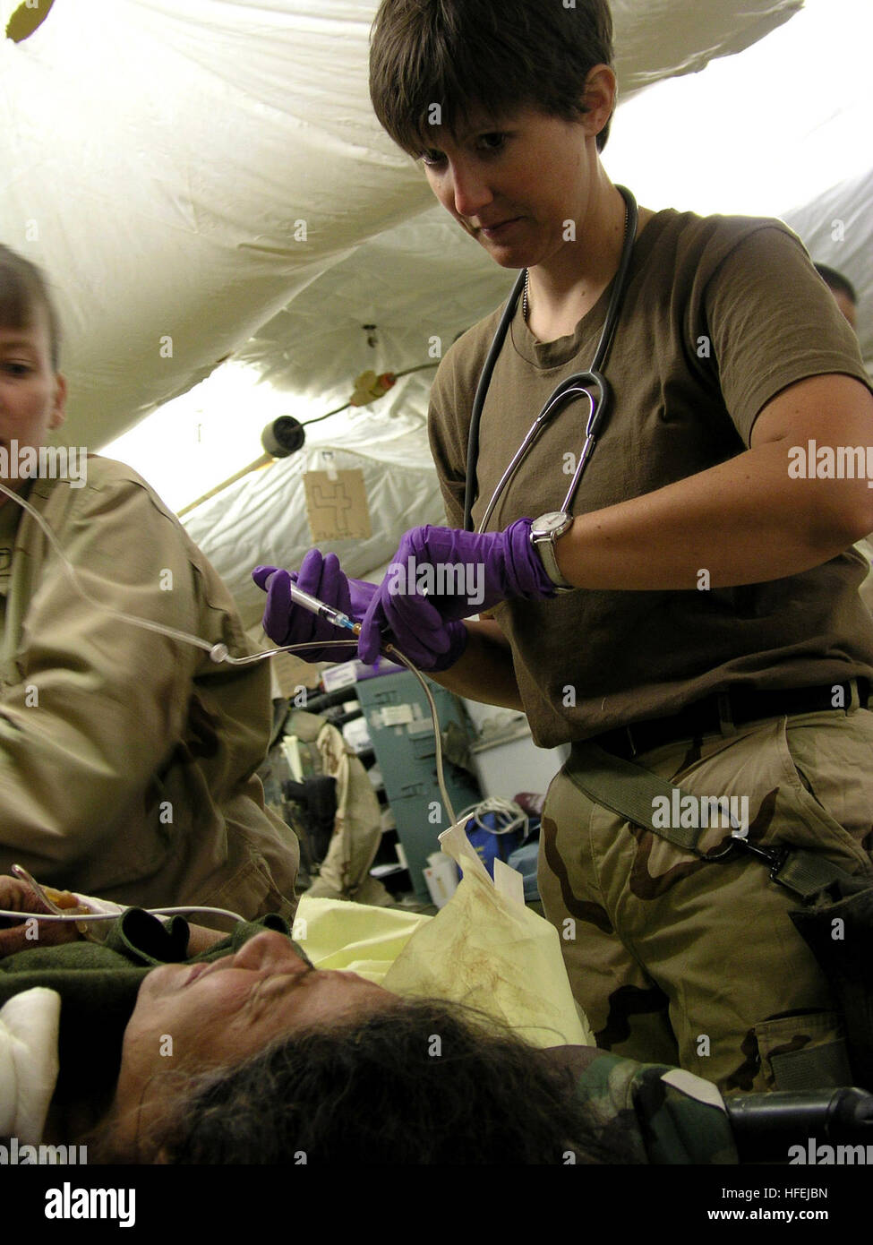 030414-N-0728B-002 de la zone de responsabilité du Commandement central (avr. 14, 2003) -- L'Étoile Jill Skeet de Williamsburg, Kan., administre les médicaments contre la douleur d'une femme irakienne non identifiés qui sont arrivés en Hôpital ThreeÕs (FH-3) Casualty pièce de réception avec une blessure par balle. FH-3 le personnel a vu plus de 500 patients et a mené plus de 280 interventions chirurgicales, puisque la construction du NavyÕs première installation médicale expéditionnaire dans une zone de combat et de voir leur premier patient le 1er avril. FH-3agir de capacités chirurgicales rang de l'oreille, du nez et de la gorge et à l'orthopédie et de chirurgie de neurones, Ophtalmologie Banque D'Images