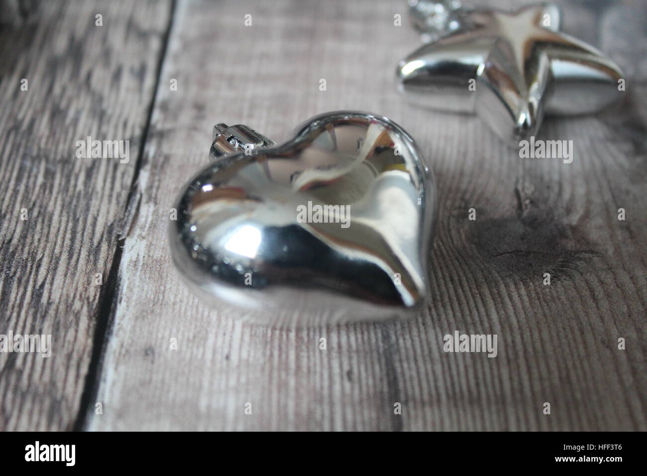 Coeur en argent sur un plancher de bois Banque D'Images