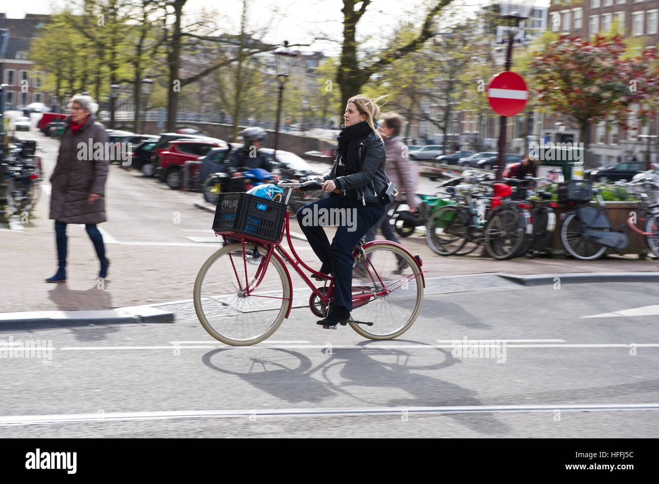 Un cycliste féminin sur la rue à Amsterdam, Hollande, Pays-Bas. Il y a environ un million de bicyclettes. Banque D'Images