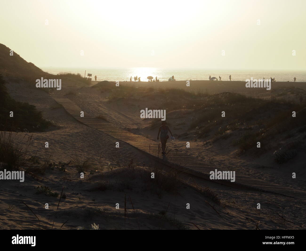 Personne waling passerelle sur le bois de la plage au coucher du soleil Banque D'Images