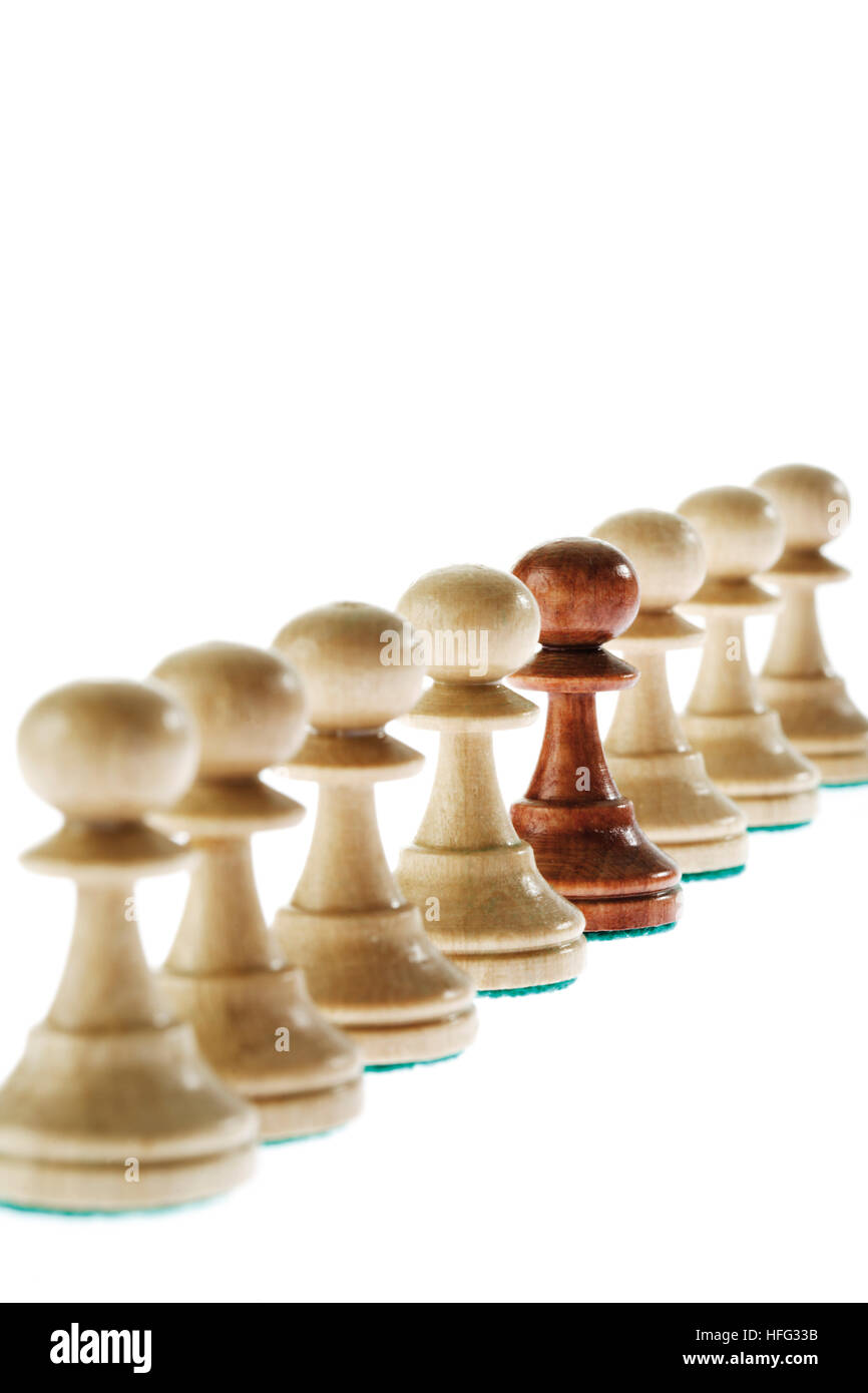 Pièces des échecs : l'un foncé parmi plusieurs pions blancs Banque D'Images