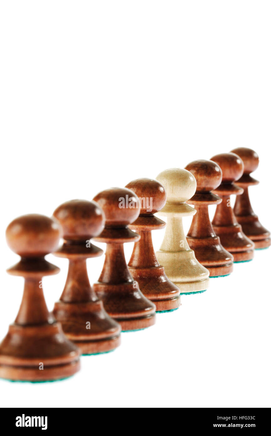 Pièces des échecs : l'un blanc entre plusieurs pions marron Banque D'Images