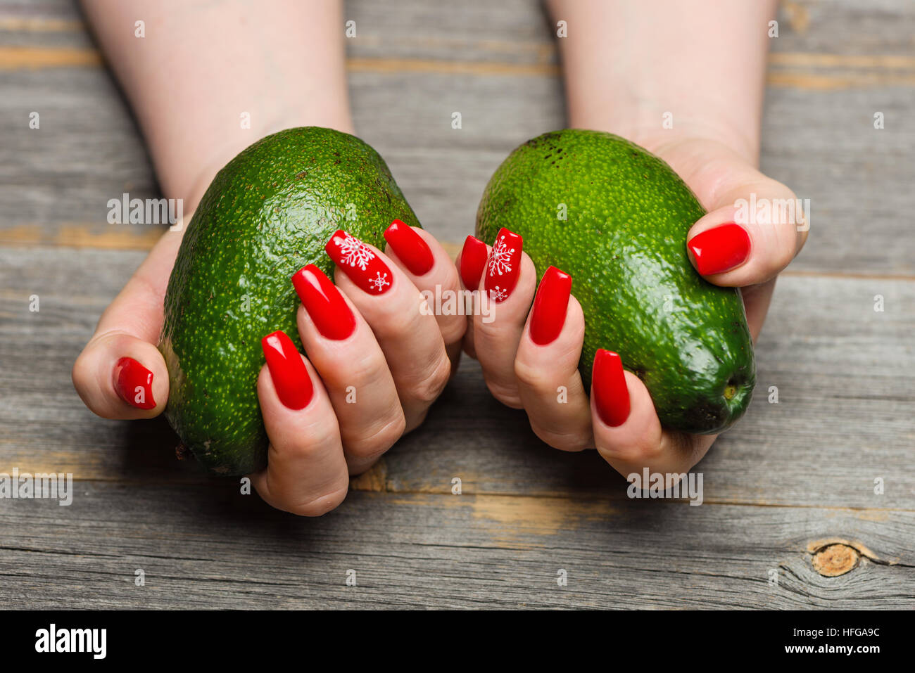 Femme avec de belles mains manucure du Nouvel An garder dans un style fruits d'avocat rustic Banque D'Images