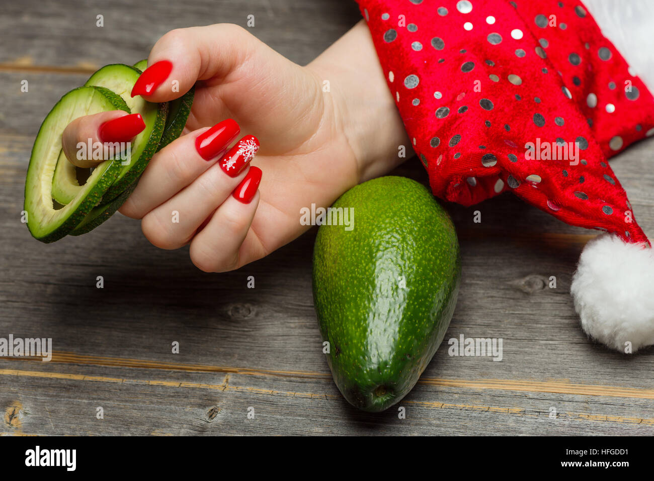 La part des femmes avec de belles fêtes de Nouvel An manucure détient la coupe de fruits Avocat par bagues Banque D'Images