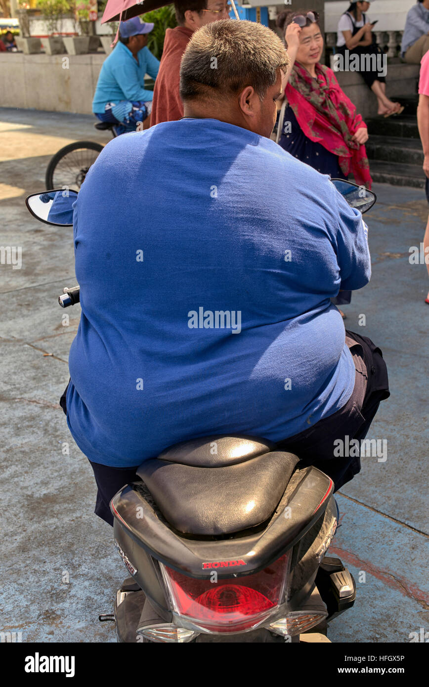 Obésité gros homme à cheval sur un moto. S. E. Asie Thaïlande Photo Stock -  Alamy
