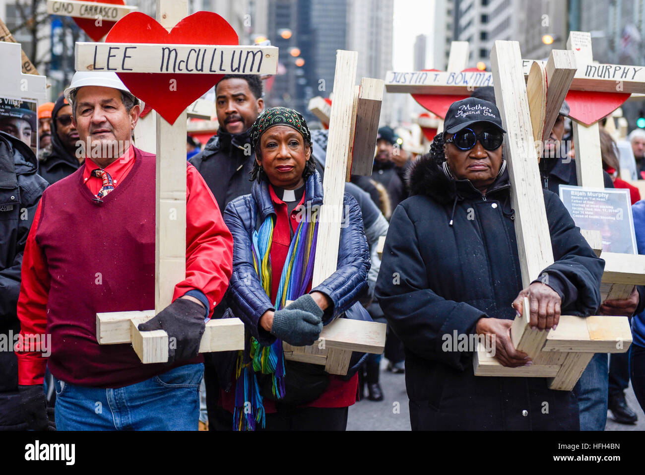 Chicago, USA. 31 décembre 2016. Une marche pour la paix, organisé par le Père Michael Pfleger et fabricant de la croix, Greg Zanis (L), qui a lieu vers le bas du Magnificent Mile de Chicago, Michigan Avenue, pour honorer les survivants et les victimes de l'escalade de la ville de la violence armée. Les manifestants portent un 2-foot-tall blanche en bois, portant chacune le nom d'une personne tuée par la violence armée en 2016. Avec plus de 4 300 tirs et plus de 750 personnes tuées en 2016, ce sont les plus hauts totaux pour 20 ans et plus que toute autre grande ville des États-Unis en 2016, selon les bulletins de nouvelles. © Stephen Chung / Alamy Live News Banque D'Images