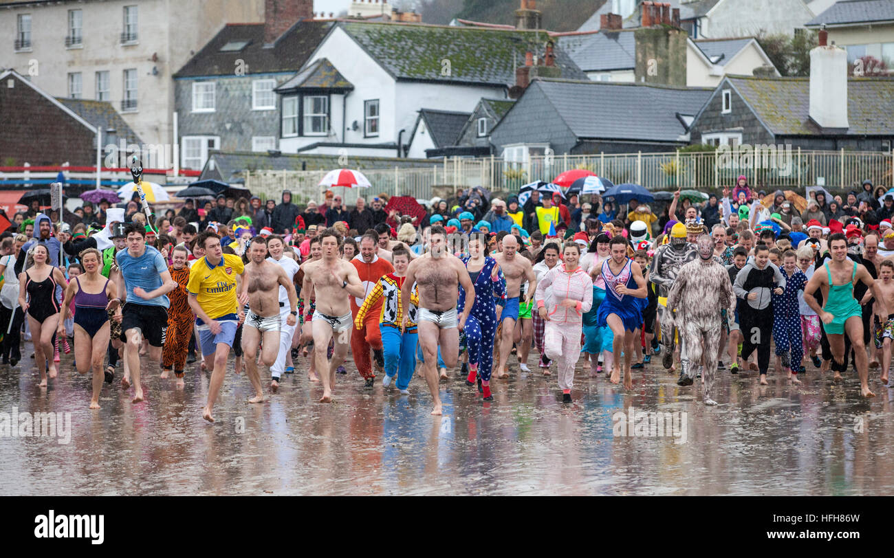 Des centaines se sont déguisés en dépit de la pluie pour prendre part à la "fente de Lyme' - un jour de l'an 2016 nager à Lyme Regis Banque D'Images