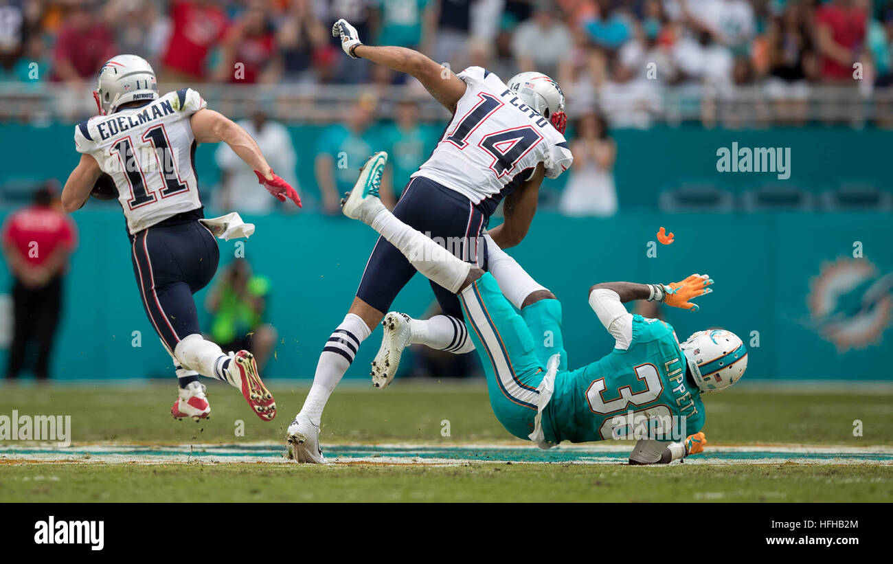 Miami Gardens, Florida, USA. 1er janvier 2017. New England Patriots receveur Julian Edelman (11) après l'obtention d'un bloc par New England Patriots wide receiver Michael Floyd (14) sur Miami Dolphins Tony évoluait Lippett (36) au Hard Rock Stadium de Miami Gardens, Floride le 1 janvier, 2017. Allen Eyestone/Le Palm Beach Post/ZUMA/Alamy Fil Live News Banque D'Images