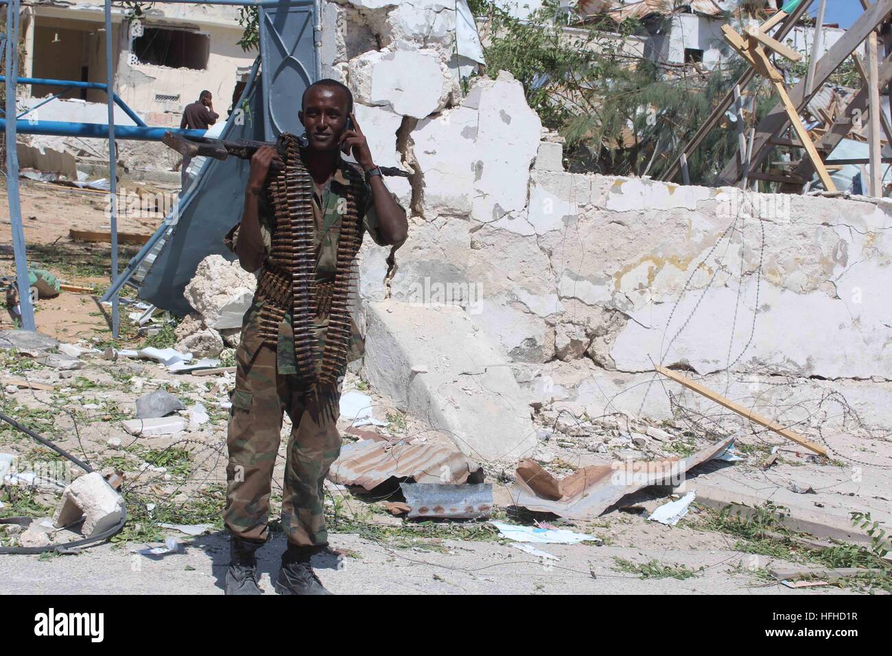 Mogadiscio, Somalie. 2 Jan, 2017. Un homme se tient à la sécurité près de la scène de l'attentat-suicide à Mogadiscio, capitale de la Somalie, le 2 janvier, 2017. Au moins deux personnes ont été tuées et plusieurs autres blessées dans des explosions de lits jumeaux par groupe extrémiste Al-Shabaab près de la base de la Mission de l'Union africaine en Somalie (AMISOM) et un hôtel de luxe dans la capitale Mogadishu lundi. © Faisal Miu/Xinhua/Alamy Live News Banque D'Images