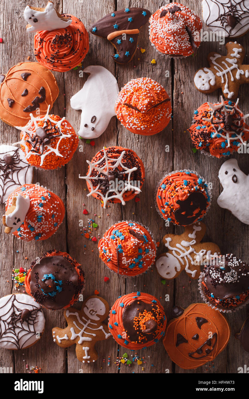 Cupcakes Halloween et gingerbread cookies sur la table verticale Vue de dessus. Banque D'Images