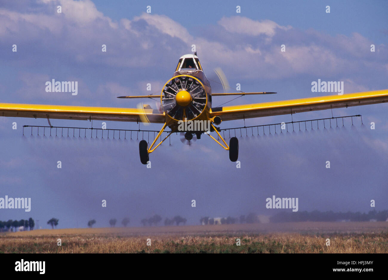 Un avion pulvérisateur agricole jaune émet un champ agricole avec des pesticides. L'application aérienne, ou ce qui était auparavant appelé poudrage des récoltes, Banque D'Images