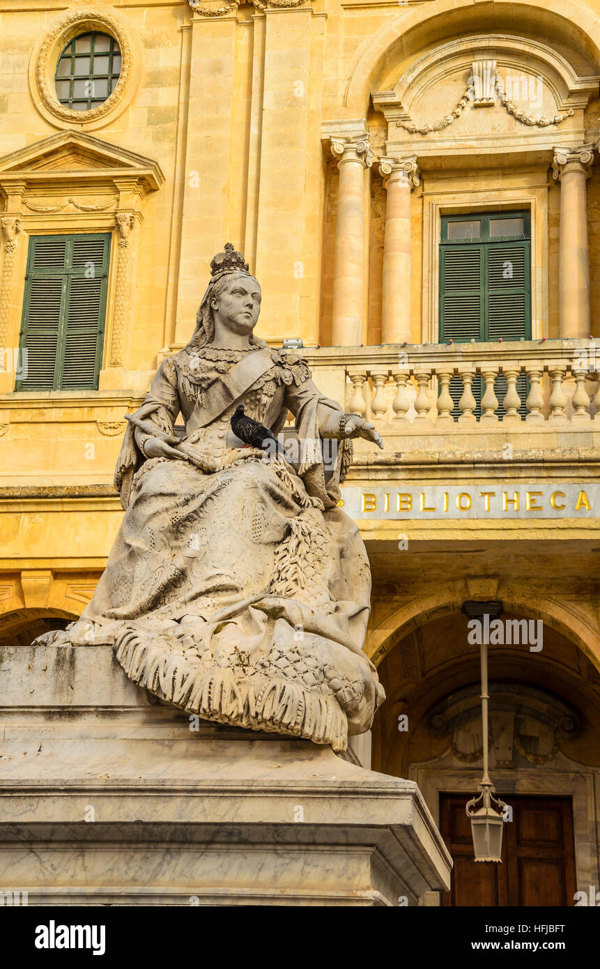 Statue de la reine Victoria, Place de la République, La Valette, Malte, Europe. Avec la Bibliothèque Nationale de Malte de calcaire en arrière-plan Banque D'Images