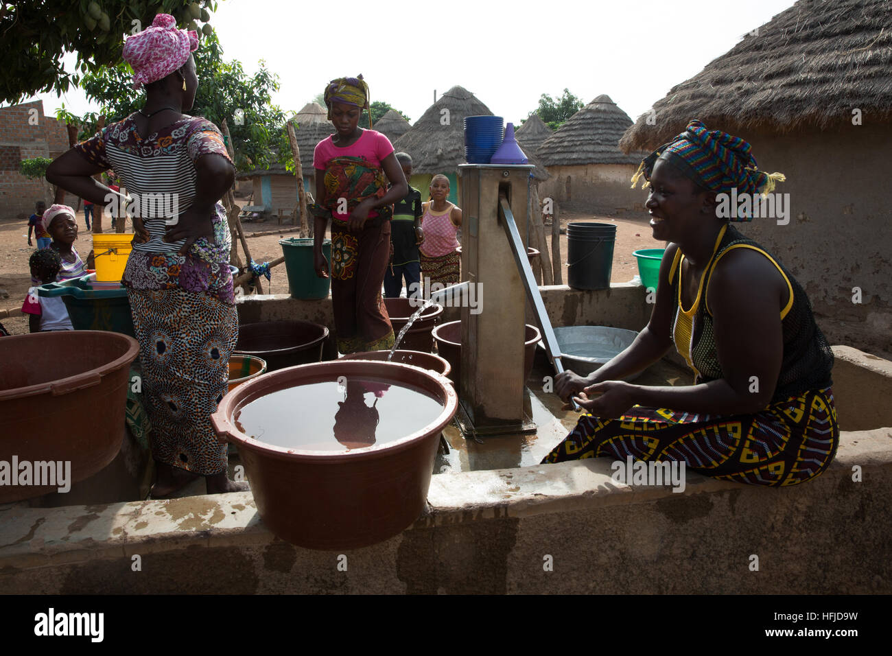 Kiniero, Guinée, le 30 avril 2015 : ce village et les environs seront inondées par le barrage de Fomi. Les femmes tirant de l'eau d'un puits près du centre du village. Banque D'Images