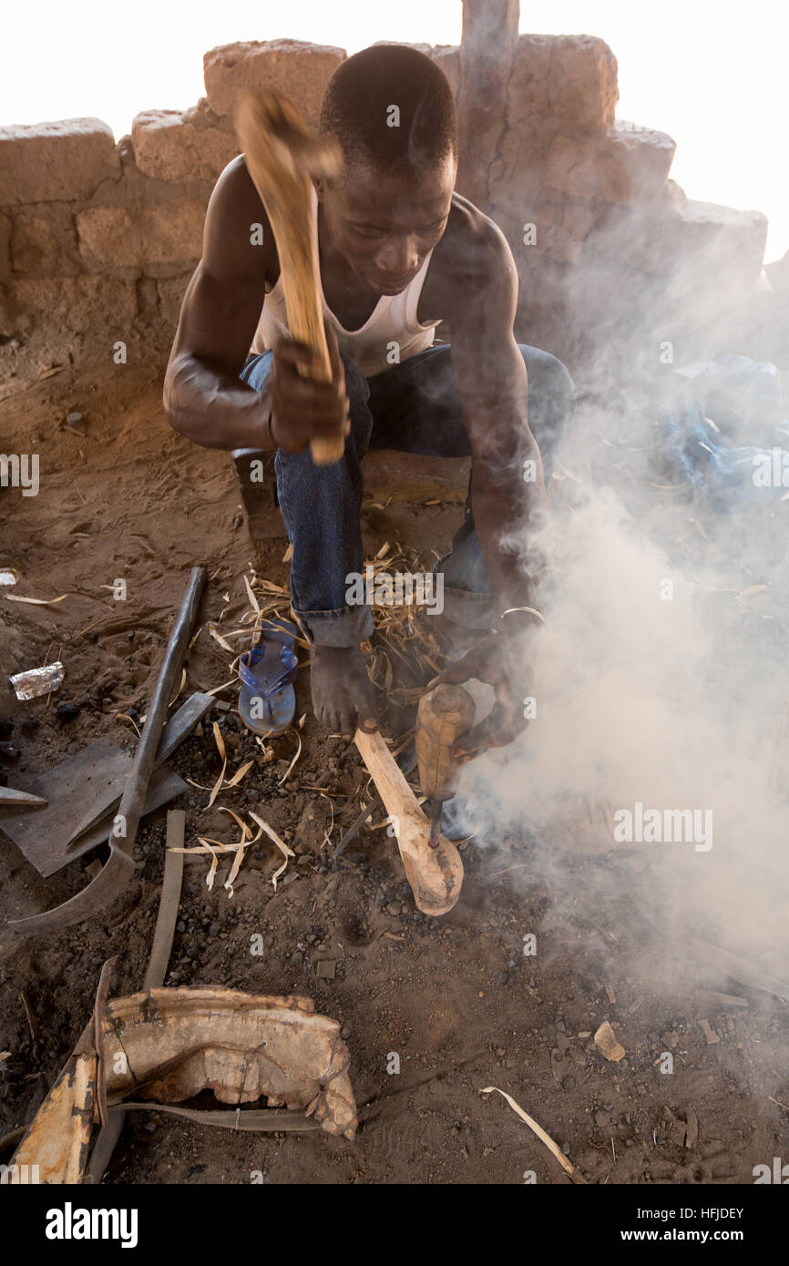 Kiniero, Guinée, le 30 avril 2015 : Mamady Camara, 35 ans, a été un forgeron depuis qu'il était un enfant, ici prendre une poignée pour une hache. Banque D'Images