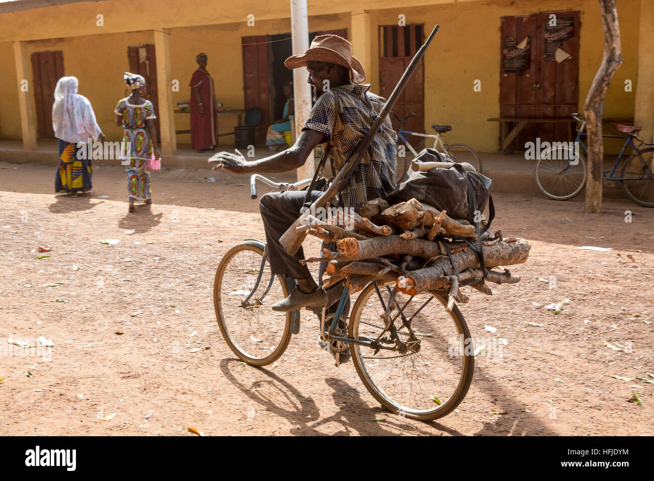 Baro, Guinée, 1er mai 2015 : village Baro est être au-dessus du niveau proposé du barrage de Fomi et recevra des personnes déplacées par le barrage. Un chasseur transporter le bois sur son vélo. Banque D'Images