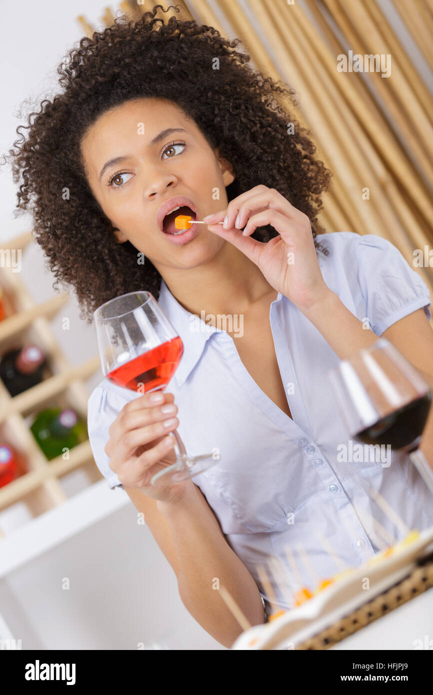Jeune femme avec verre de vin et de manger Banque D'Images