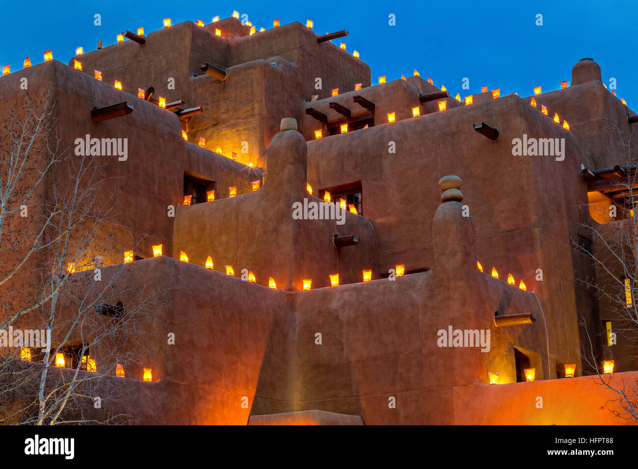 Le style adobe Inn at Loretto est éclairé par des centaines de petites lanternes en papier appelé luminaria pour célébrer la saison des vacances dans le quartier historique le 11 décembre 2015 à Santa Fe, Nouveau Mexique. Banque D'Images