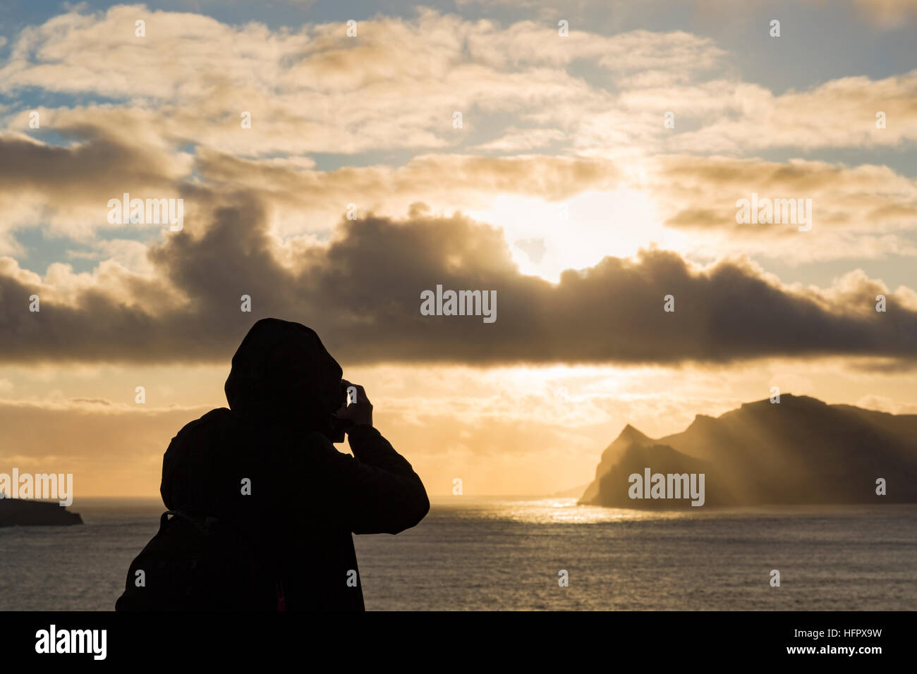 Photographe à prendre des photos des rayons de soleil sur l'île de Tindhólmur, au crépuscule, de Vagar et îles Féroé, Danemark en avril - îles Féroé Île Tindholmur Banque D'Images