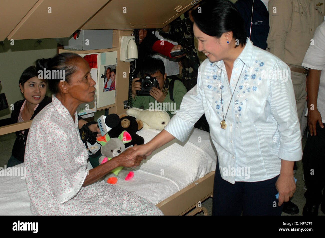 0600609-N-9076B-104 Jolo, aux Philippines (9 juin 2006) - La Présidente des Philippines, Gloria Macapagal-Arroyo accueille la grand-mère d'un enfant de 13 ans qui a subi une chirurgie à bord de la commande de transport maritime militaire (MSC) navire-hôpital USNS Mercy (T-AH 19). L'enfant venait de subir une opération prévue de longue fente labiale. Le bateau est dans son dernier jour de travail d'aide humanitaire au sud de l'île. La diversité de la miséricorde de l'équipage militaire américaines et étrangères, les organisations non gouvernementales, les professionnels de la nation hôte et traité des milliers de résidents locaux durant son séjour d'une semaine et a eu lieu Banque D'Images