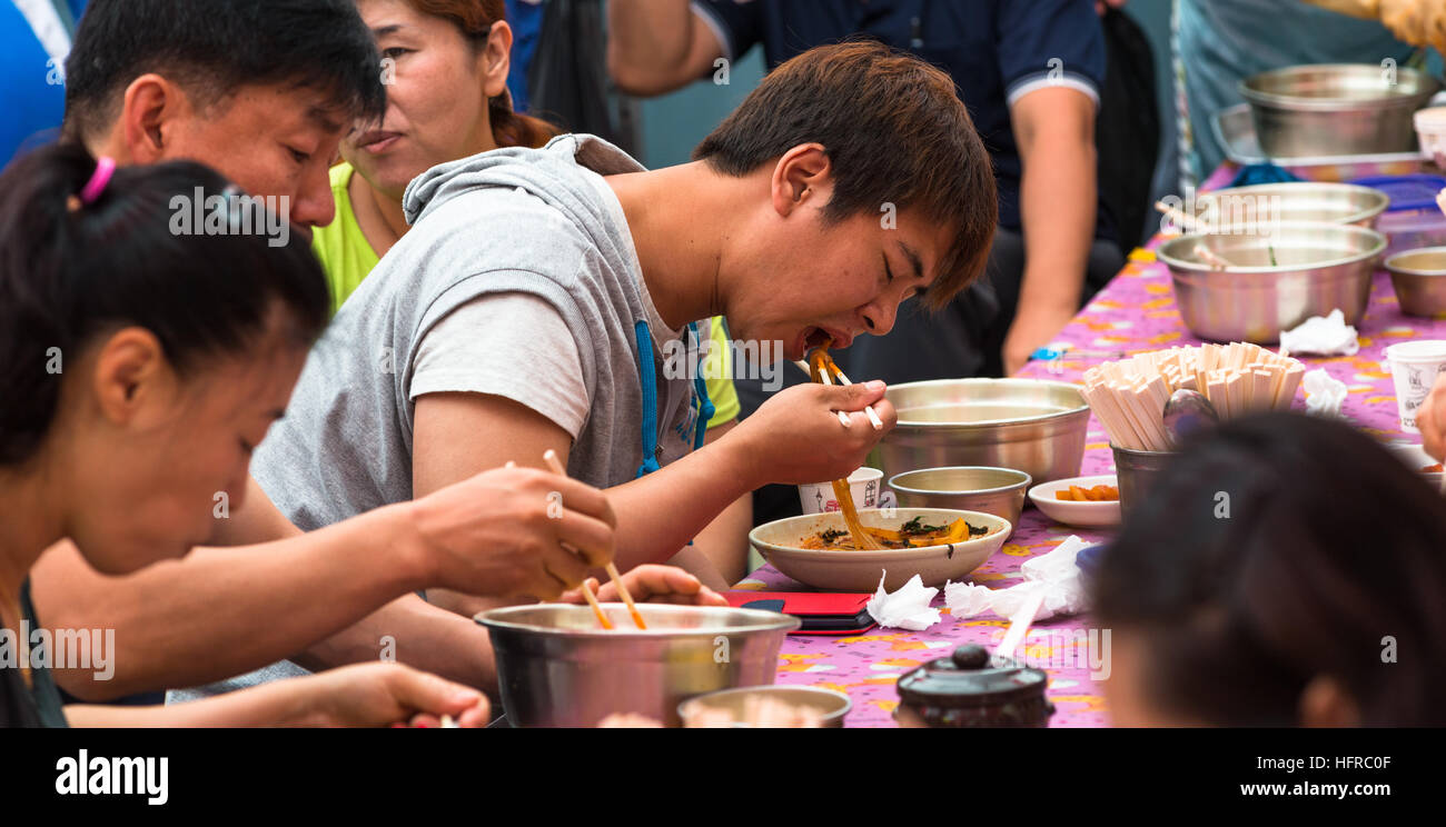 Les gens locaux mange avec des baguettes à Busan, Corée du Sud. Banque D'Images