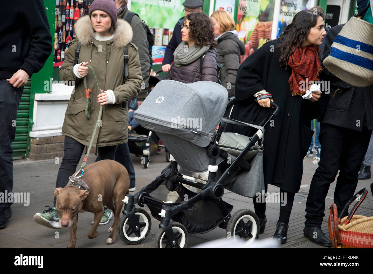Hackney. Marché de Broadway. Les acheteurs de Noël avec le chien et la pram Banque D'Images