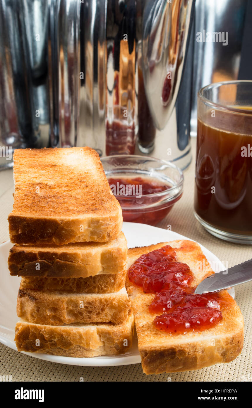 Fried toast avec de la confiture de fraise sur la table avec des ustensiles de cuisine Banque D'Images