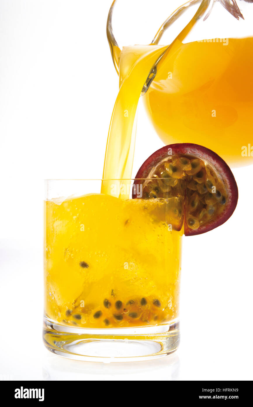Jus de fruit de la passion-Orange versé d'une cruche dans un verre Banque D'Images