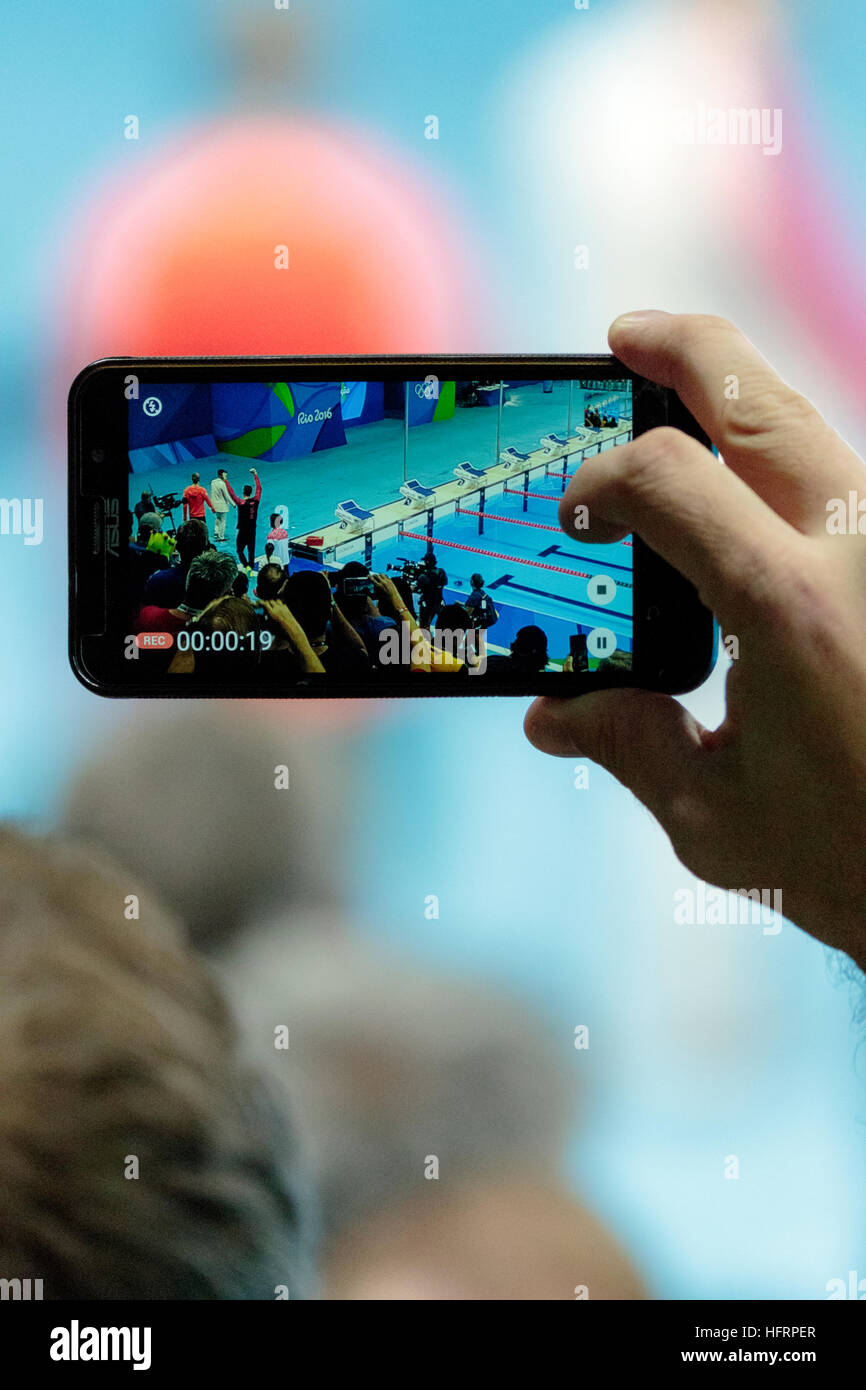 Rio de Janeiro, Brésil. 9 août 2016. À l'aide de spectateurs pour téléphone mobile photographie Michael Phelps (USA) la médaille d'or du 200m masculin butte Banque D'Images